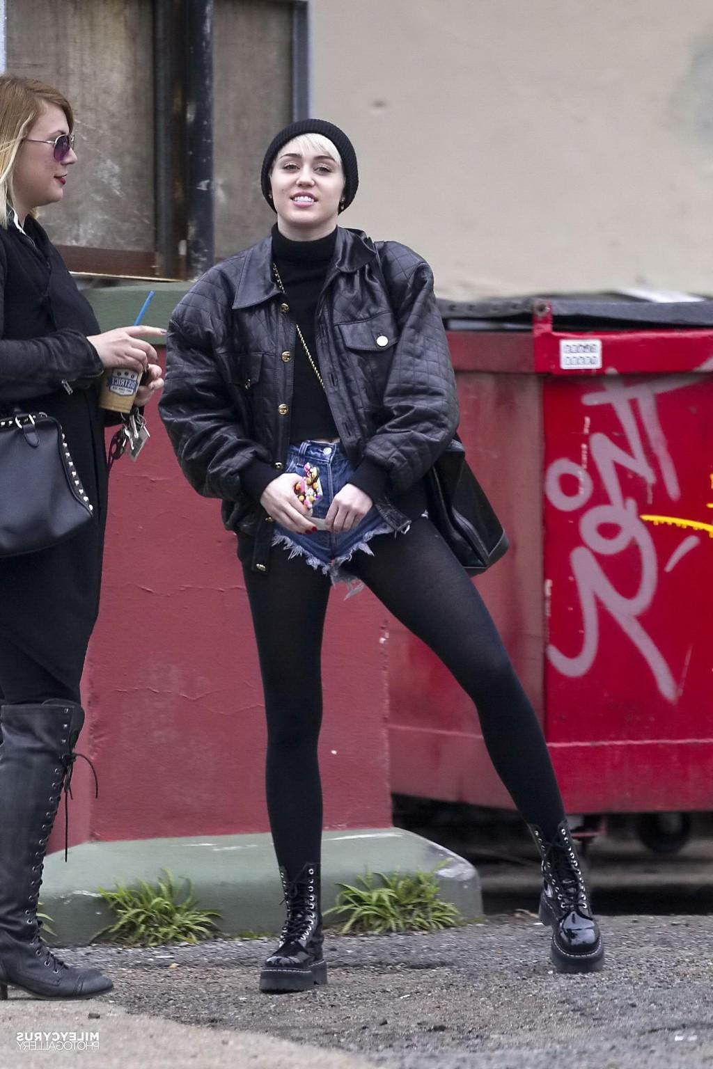 16P Miley Cyrus shows off her legs and ass wearing the denim shorts  black pantyhose