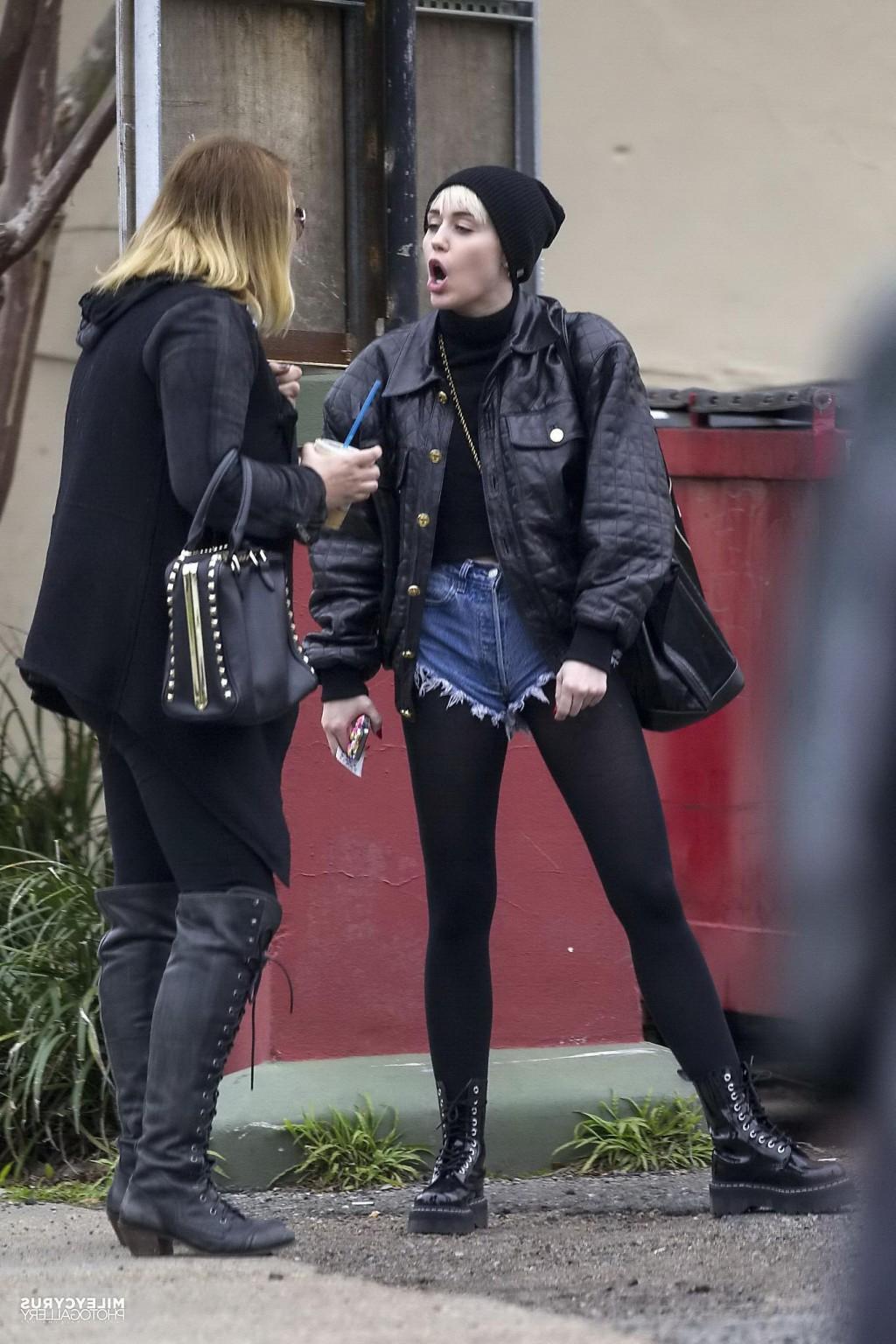 16P Miley Cyrus shows off her legs and ass wearing the denim shorts  black pantyhose