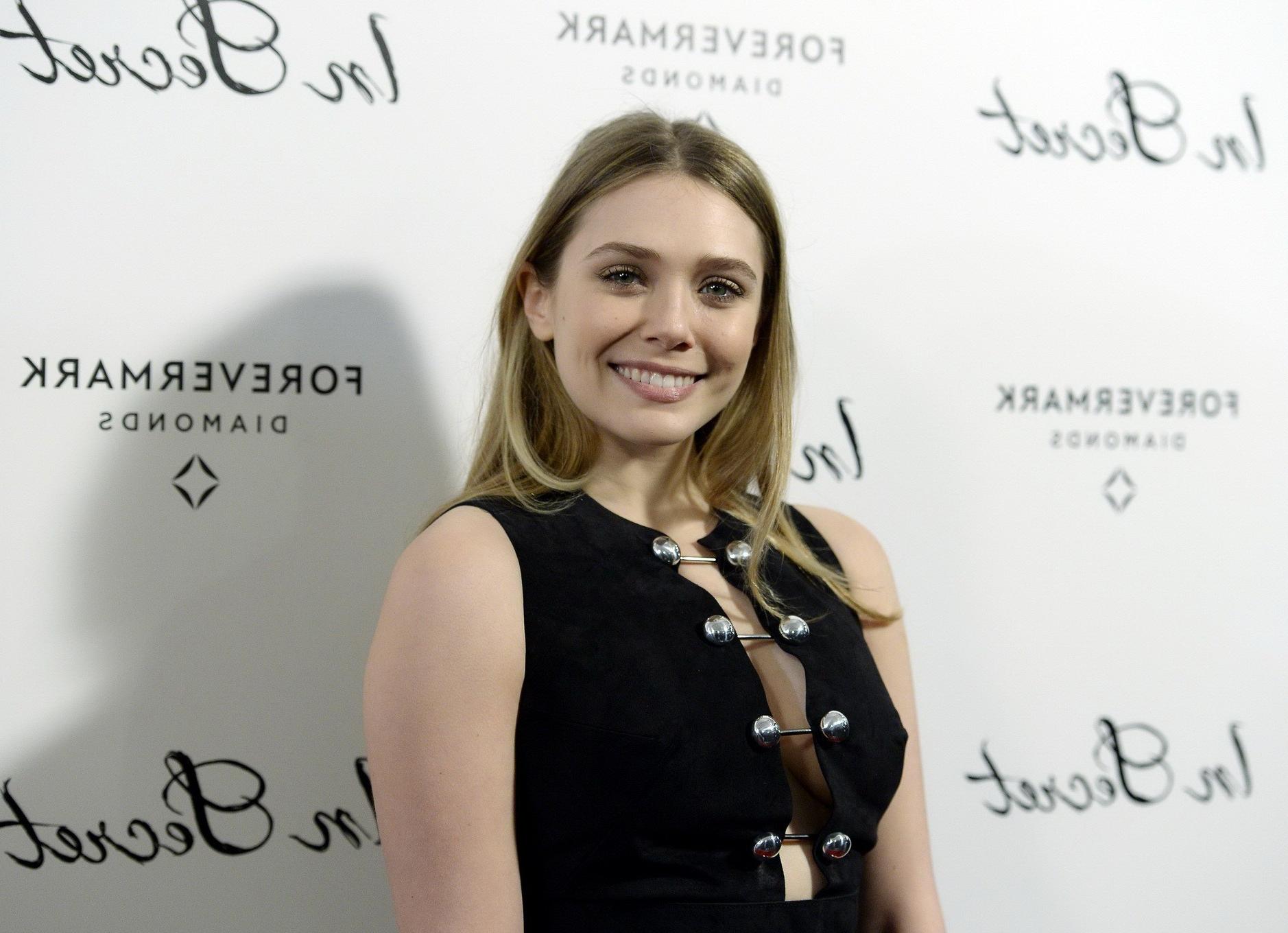 16P Elizabeth Olsen braless showing huge cleavage in a low cut black dress at the In