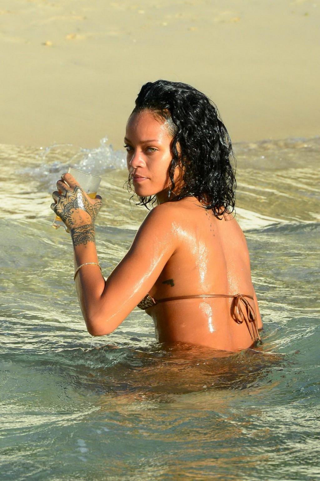 16P Rihanna showing off her perfect body in a wet string bikini at the beach in Barb