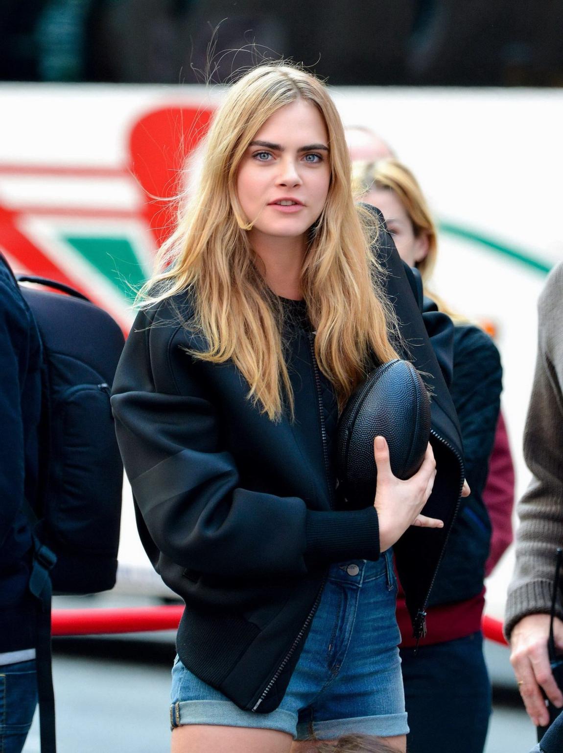 16P Cara Delevingne shows off her legs  ass wearing denim hotpants on the set of DKN