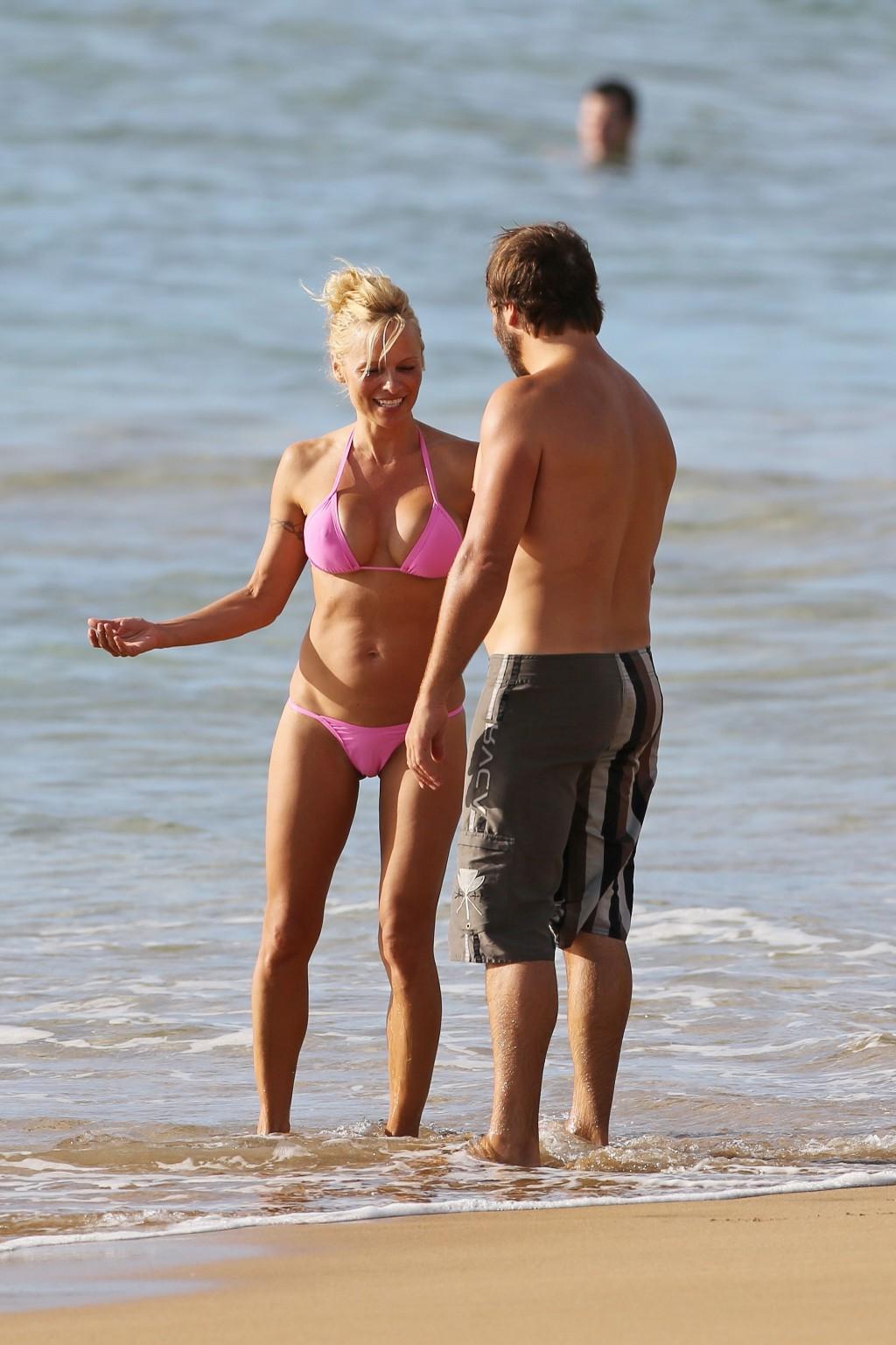 16P Pamela Anderson shows off her boobs wearing a wet see through bikini on a beach 