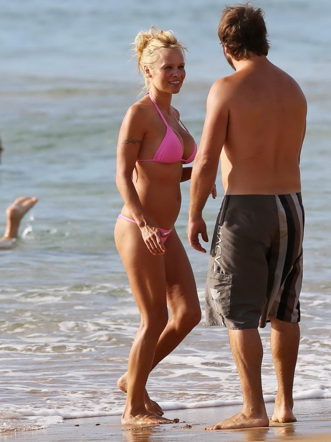 16P Pamela Anderson shows off her boobs wearing a wet see through bikini on a beach 