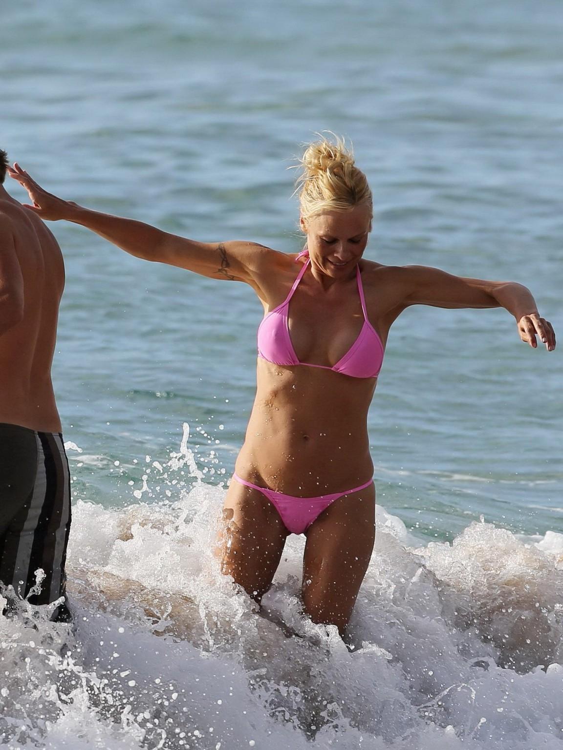 16P Pamela Anderson shows off her boobs wearing a wet see through bikini on a beach 