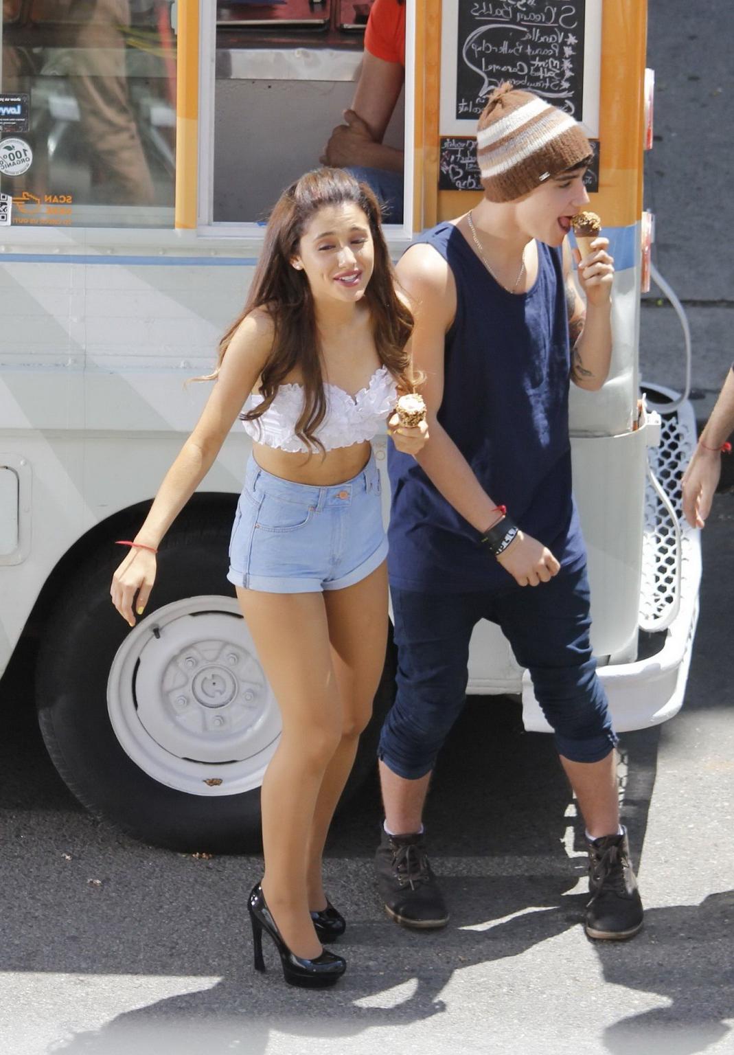 16P Ariana Grande wearing white bikini top and denim shorts while filming her new mu