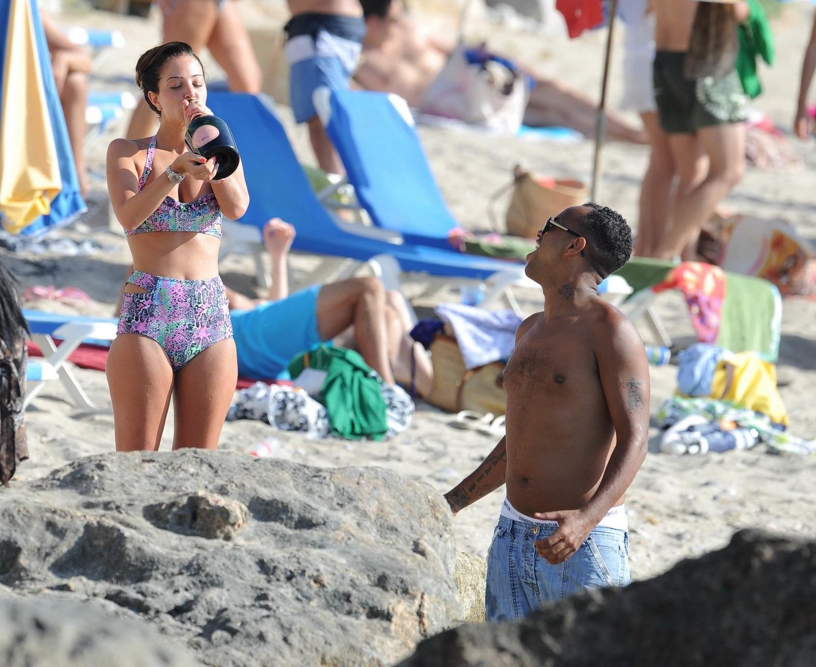 16P Tulisa Contostavlos drinks champagne from a bottle wearing skimpy colorful retro