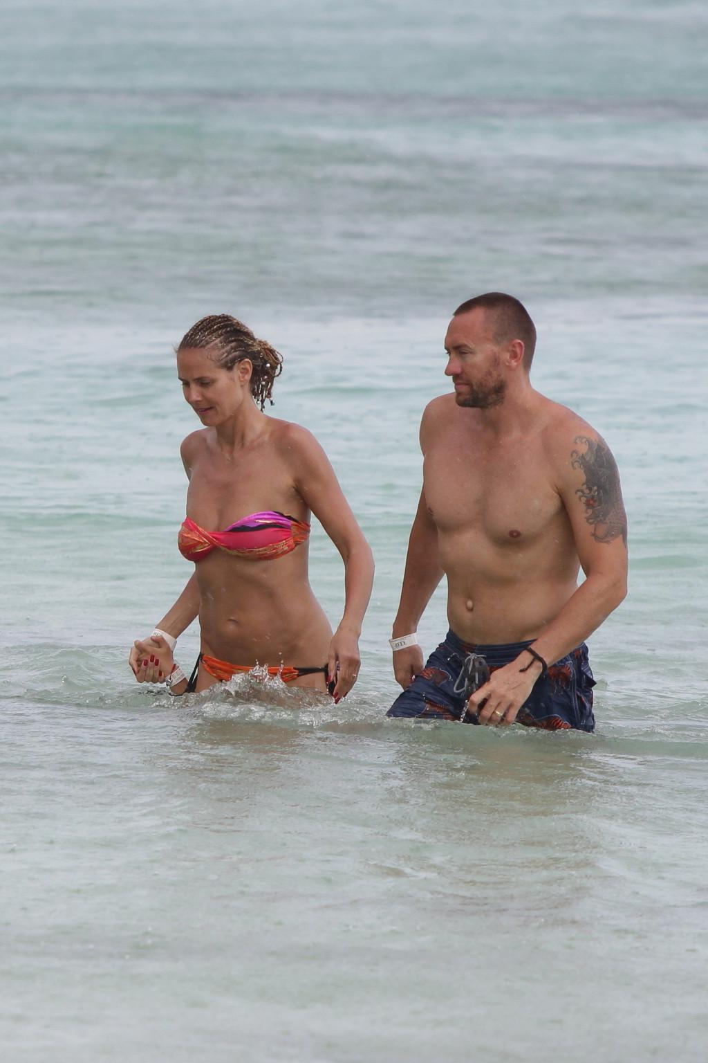 16P Heidi Klum showing off her hot body in a tube colorful bikini at the beach in th