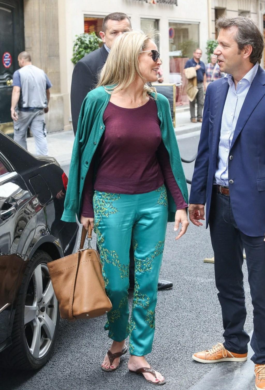 16P Sharon Stone showing off her huge boobs in a purple see-through top out in Paris