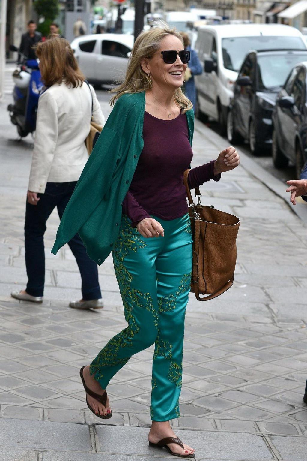 16P Sharon Stone showing off her huge boobs in a purple see-through top out in Paris