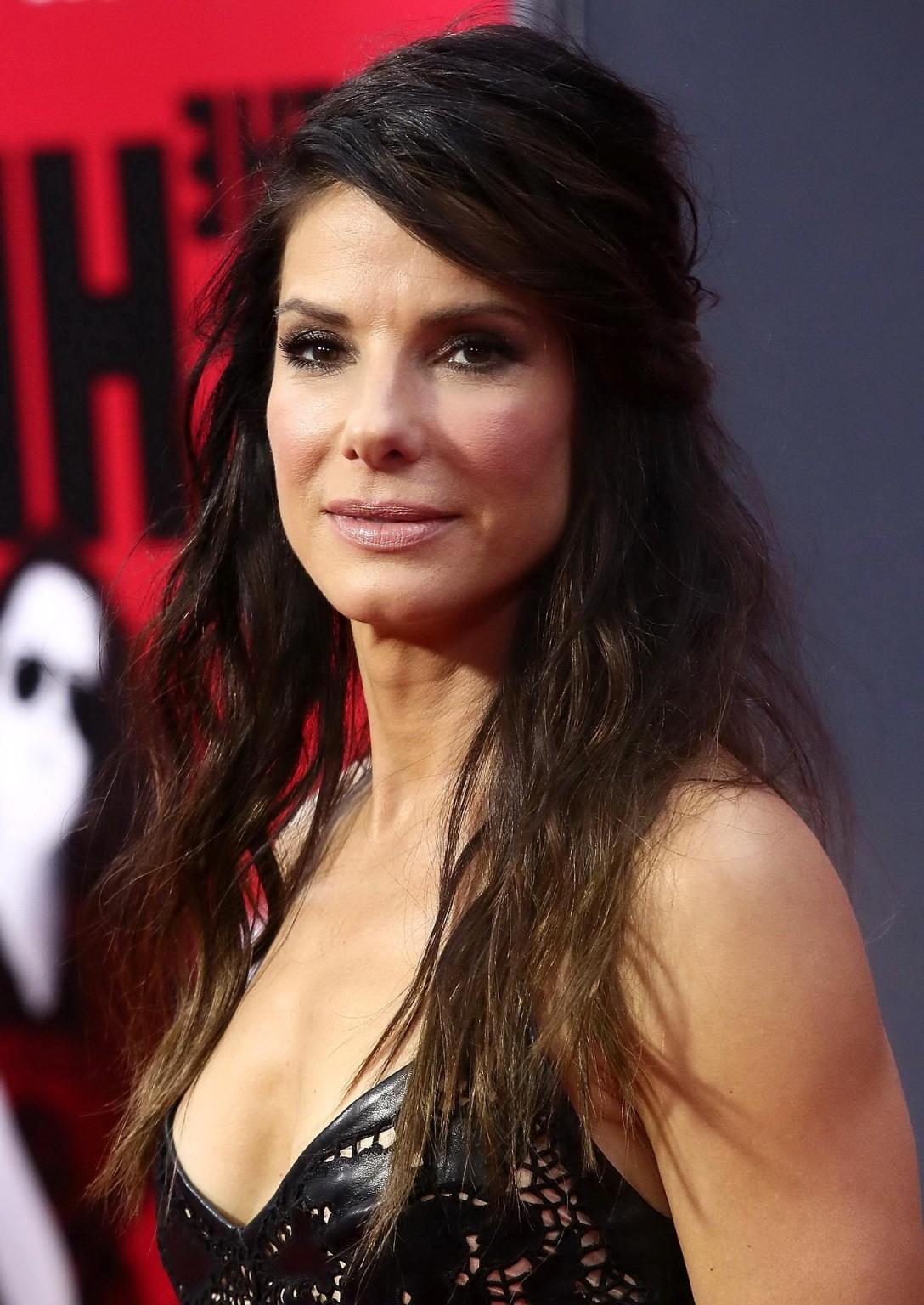 16P Sandra Bullock braless wearing a low cut leather dress at 'The Heat' premiere in