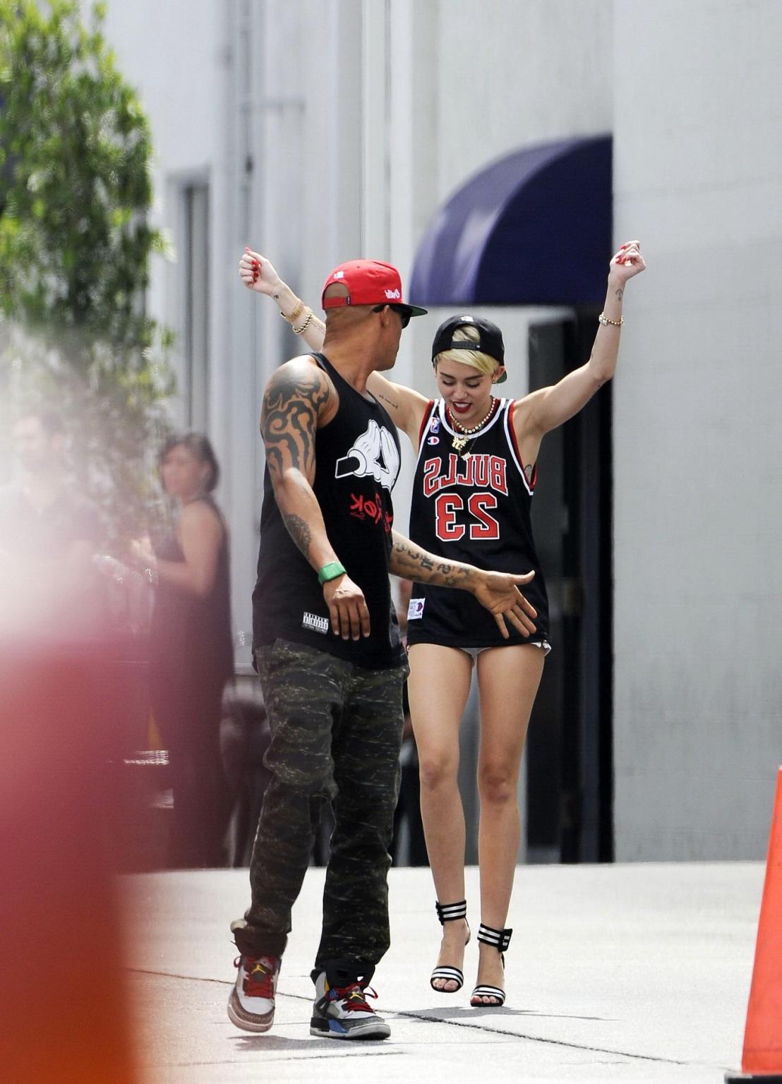 16P Miley Cyrus leggy wearing a shorts  a jersey outside a studio in LA