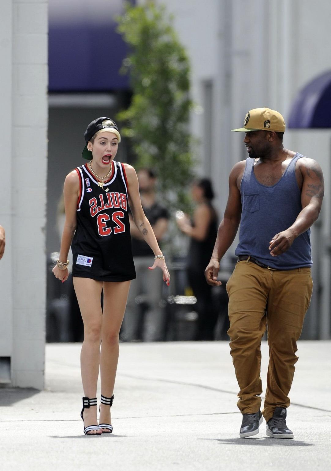 16P Miley Cyrus leggy wearing a shorts  a jersey outside a studio in LA