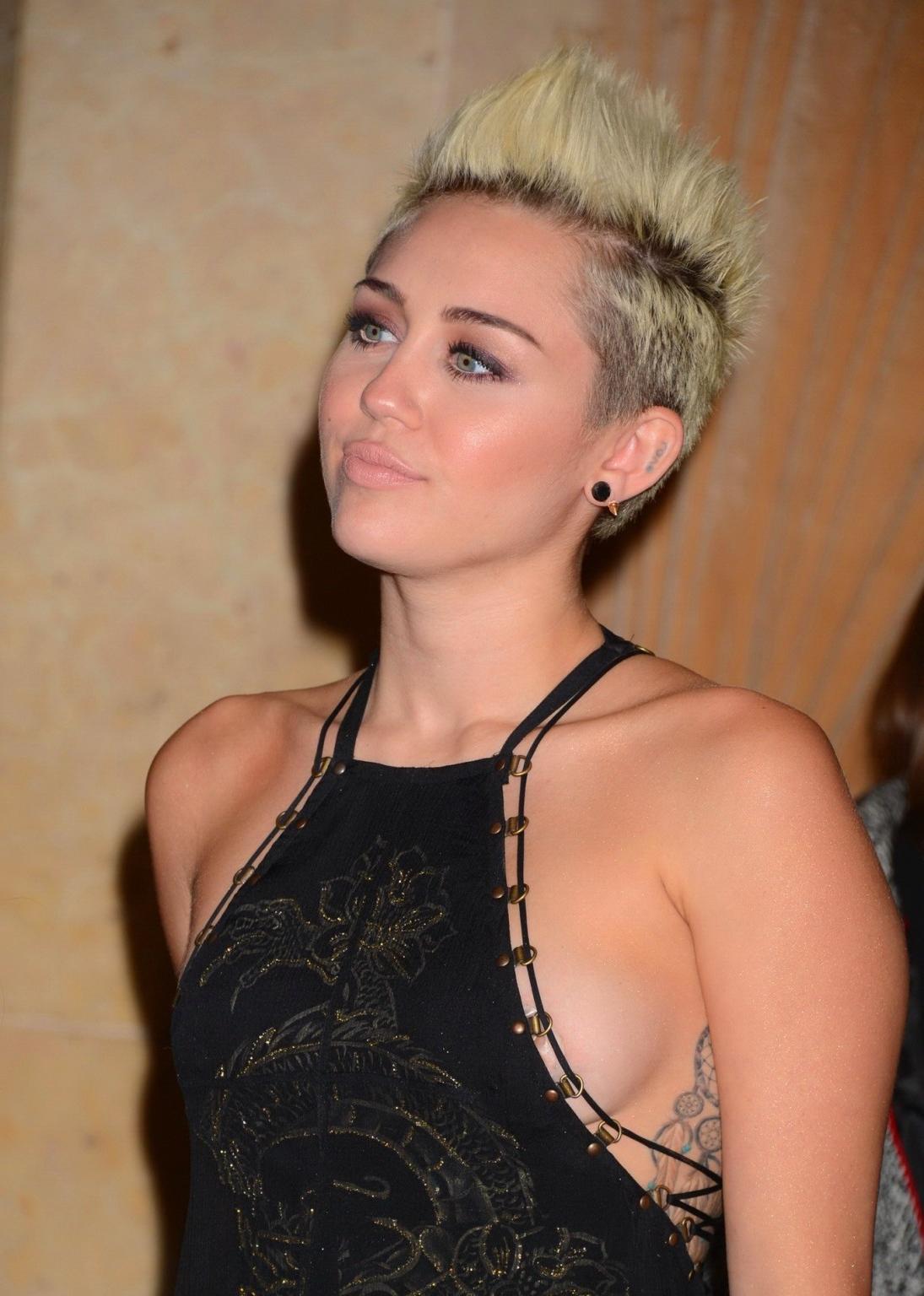 10P Miley Cyrus showing side boob in a black partially see-thru dress at Clive Davis