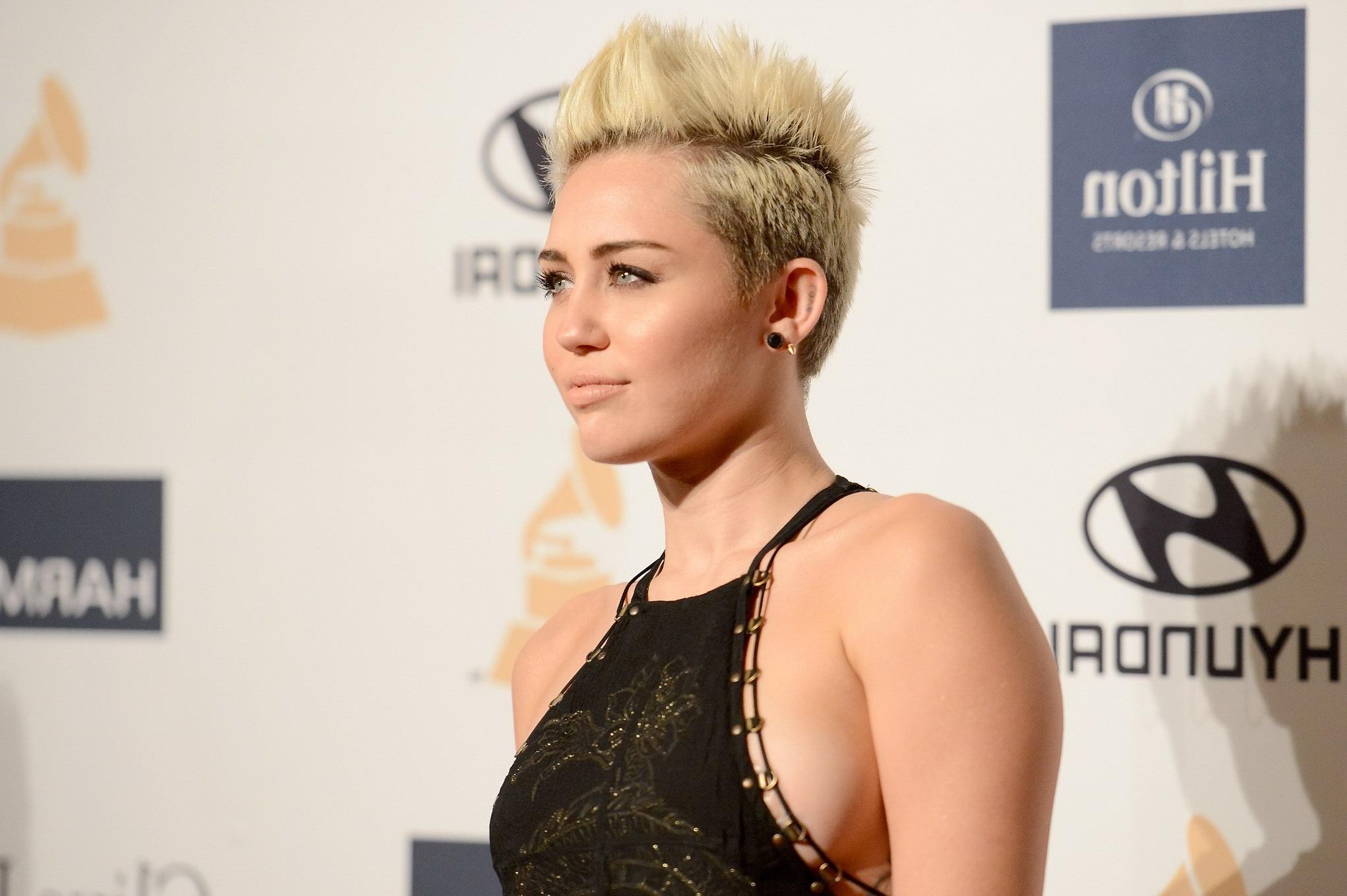 10P Miley Cyrus showing side boob in a black partially see-thru dress at Clive Davis