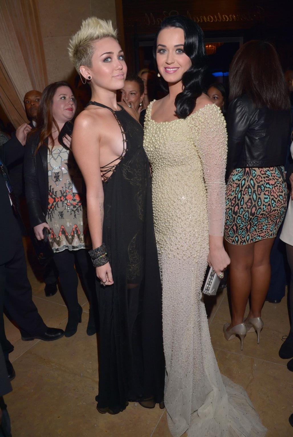 10P Miley Cyrus showing side boob in a black partially see-thru dress at Clive Davis