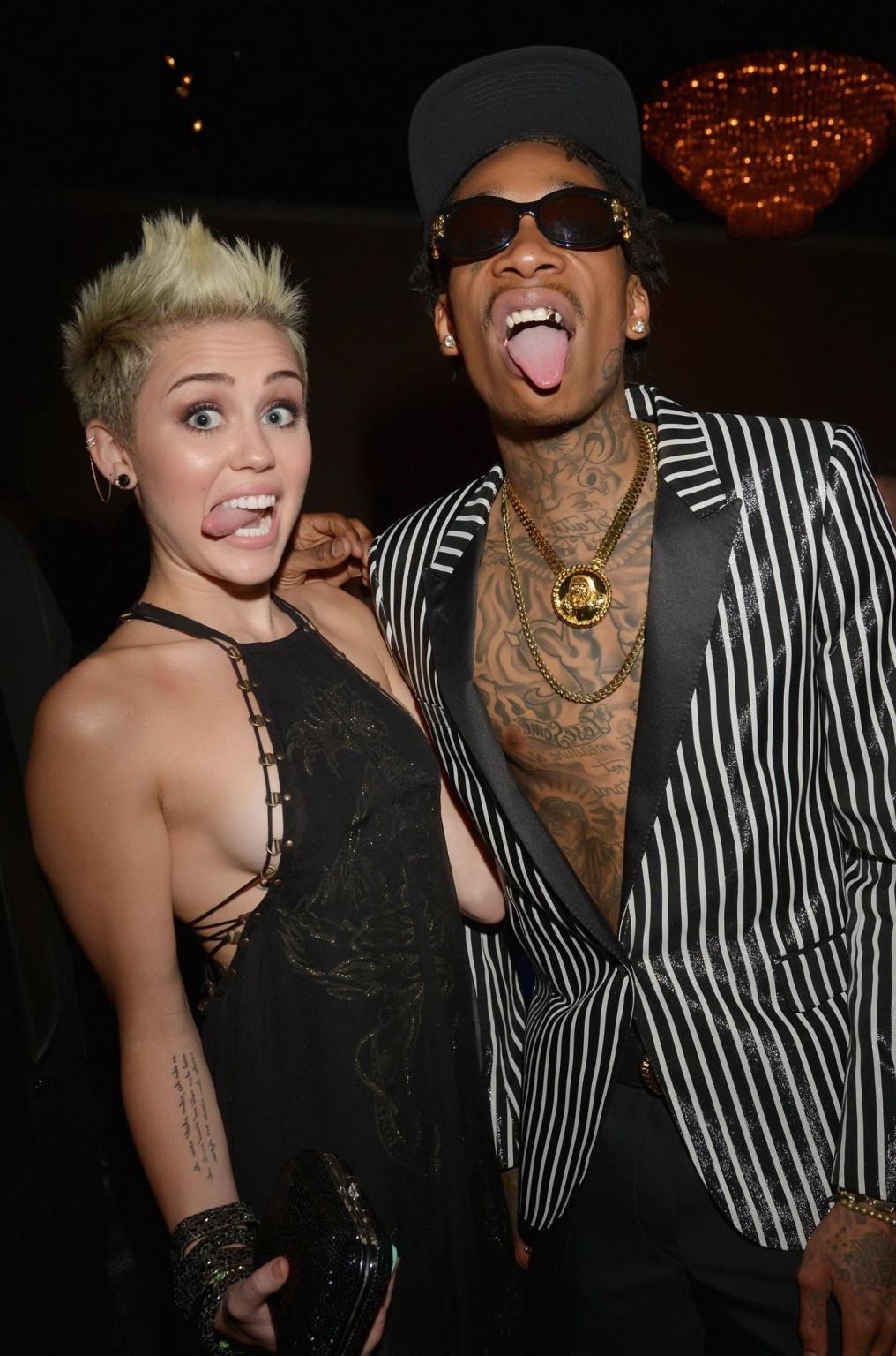 10P Miley Cyrus showing side boob in a black partially see-thru dress at Clive Davis