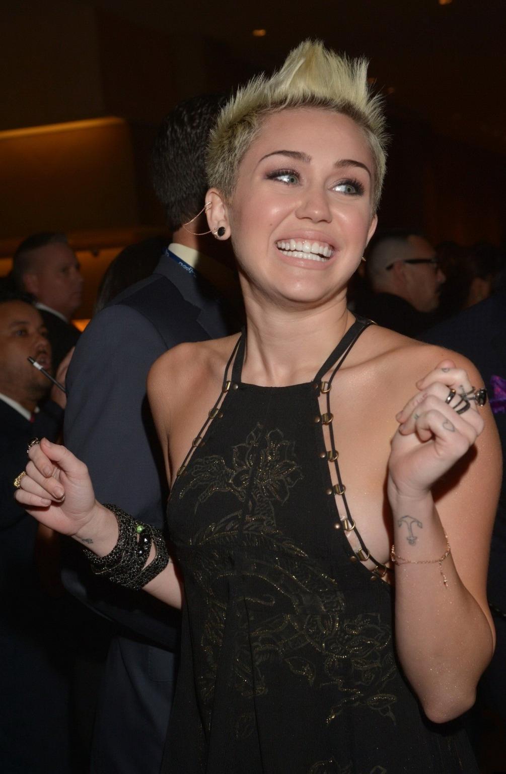 10P Miley Cyrus showing side boob in a black partially see-thru dress at Clive Davis