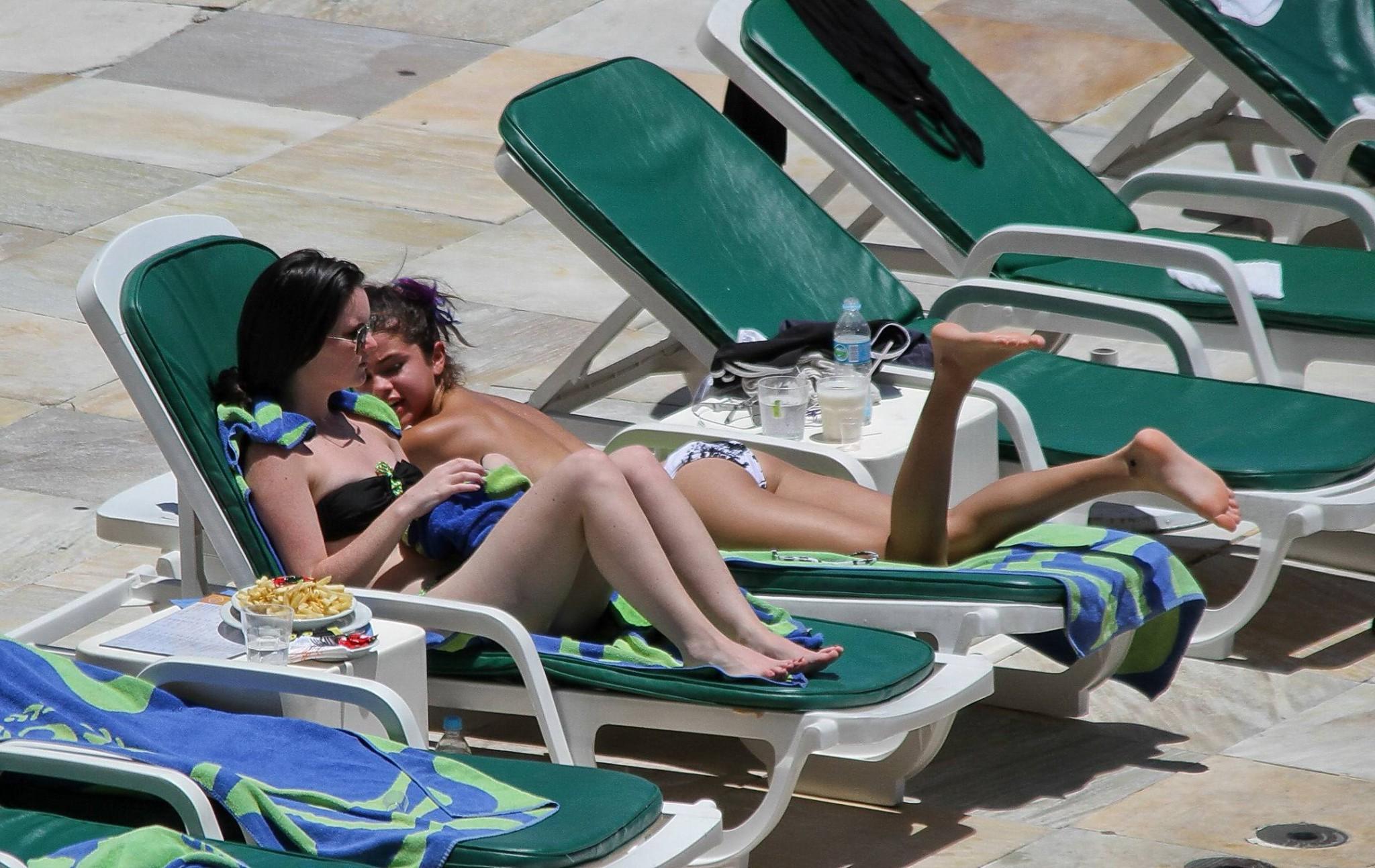 16P Selena Gomez sunbathing topless poolside in Rio de Janeiro