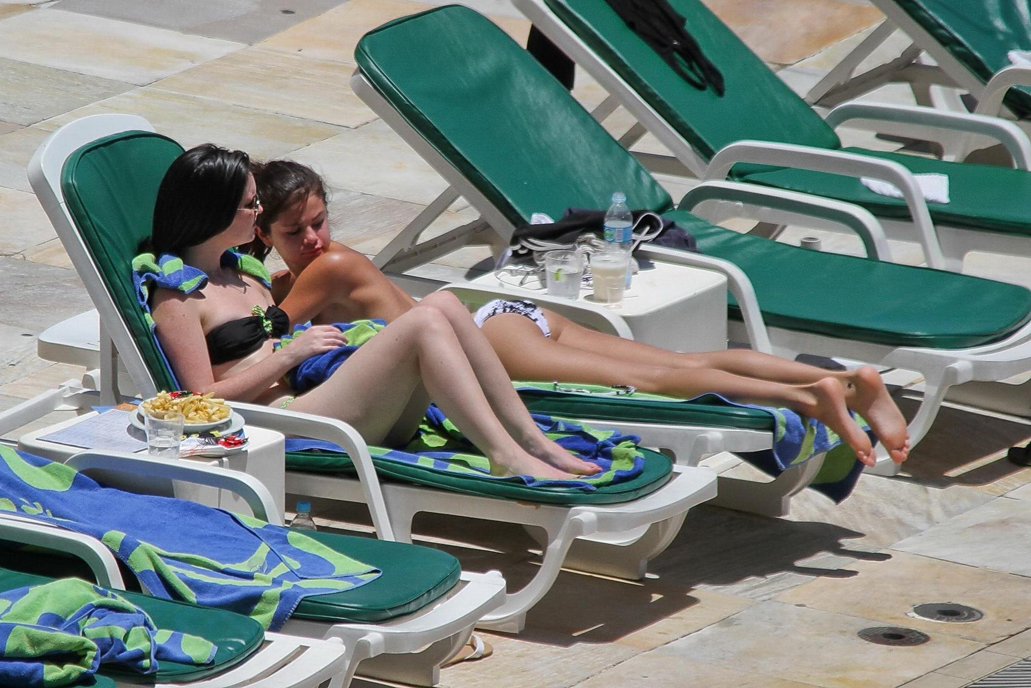 16P Selena Gomez sunbathing topless poolside in Rio de Janeiro