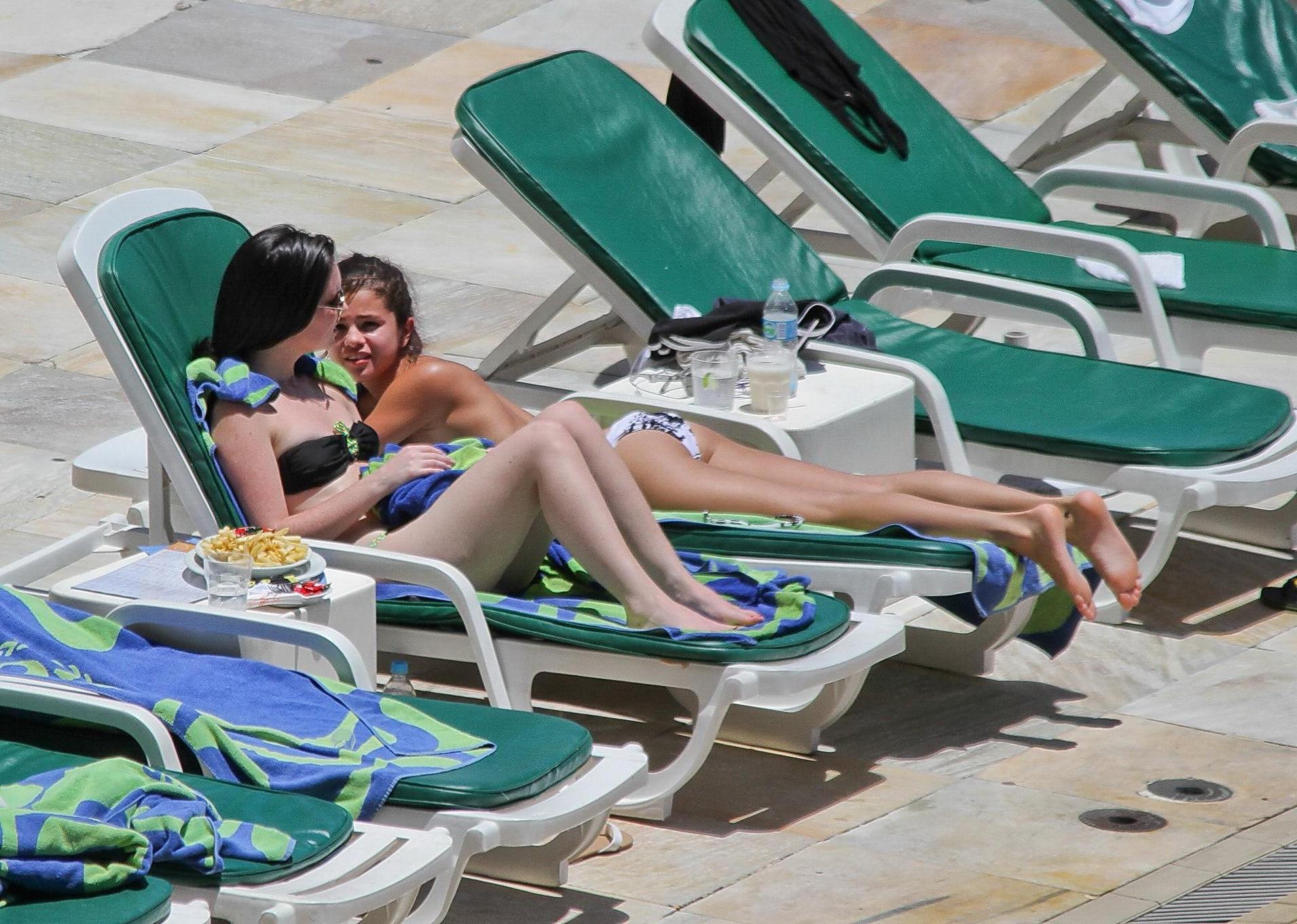 16P Selena Gomez sunbathing topless poolside in Rio de Janeiro