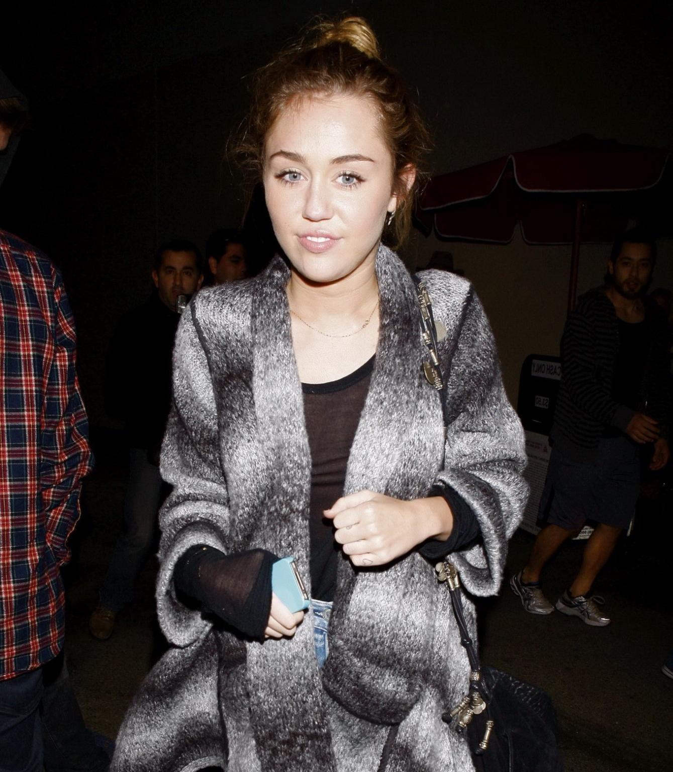 16P Miley Cyrus braless wearing black see through top outside a restaurant