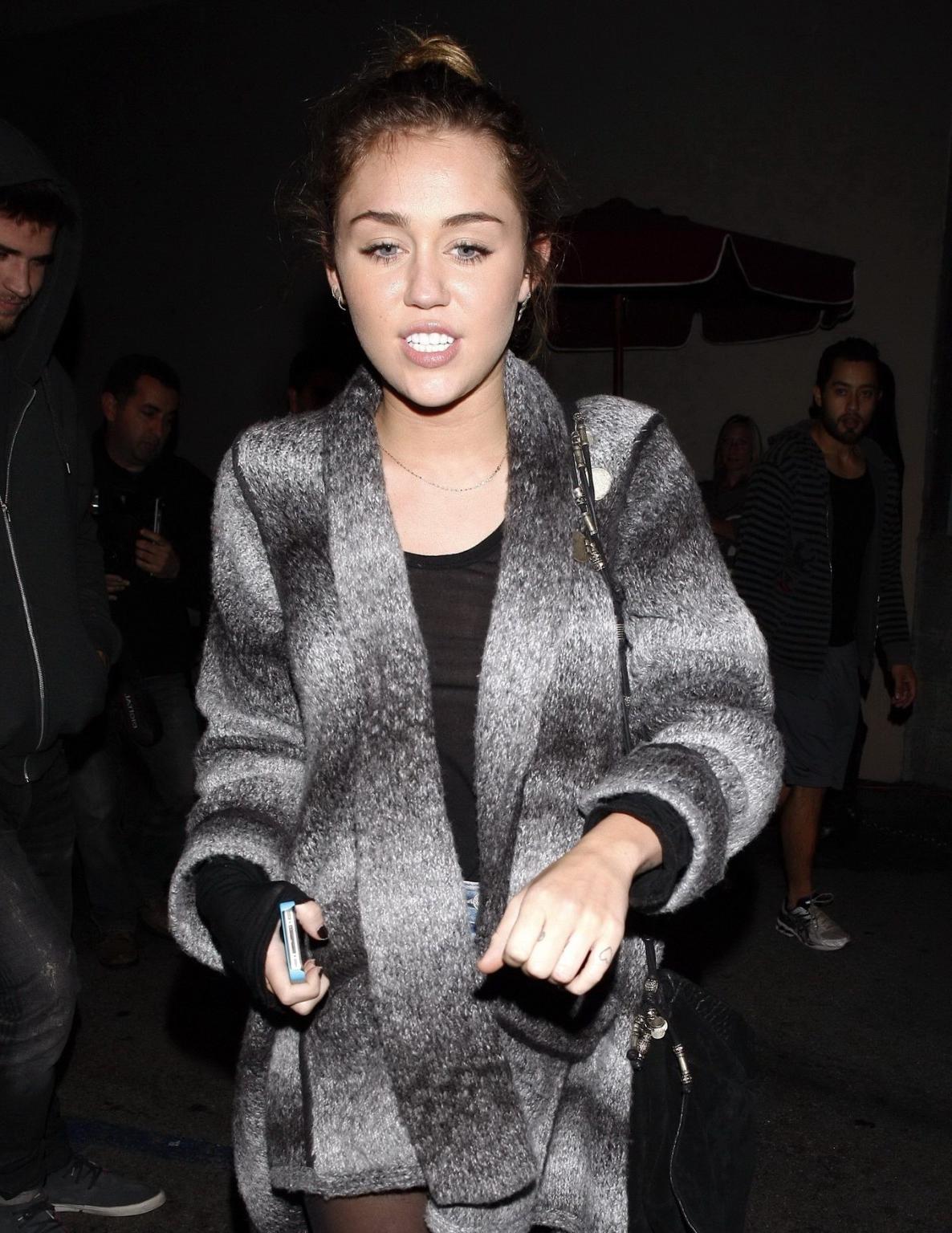16P Miley Cyrus braless wearing black see through top outside a restaurant