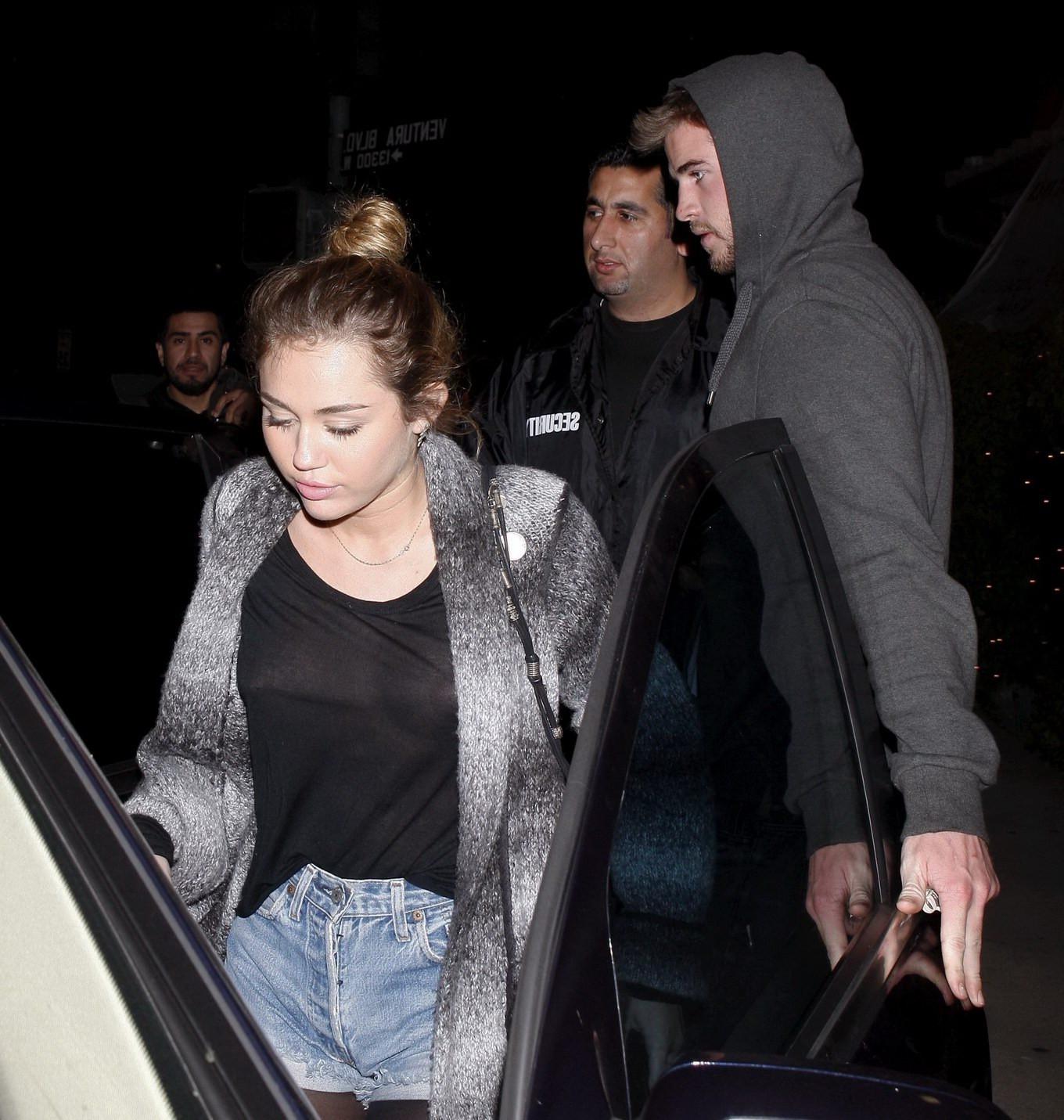 16P Miley Cyrus braless wearing black see through top outside a restaurant