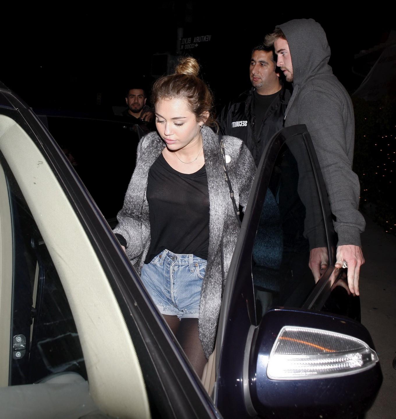 16P Miley Cyrus braless wearing black see through top outside a restaurant