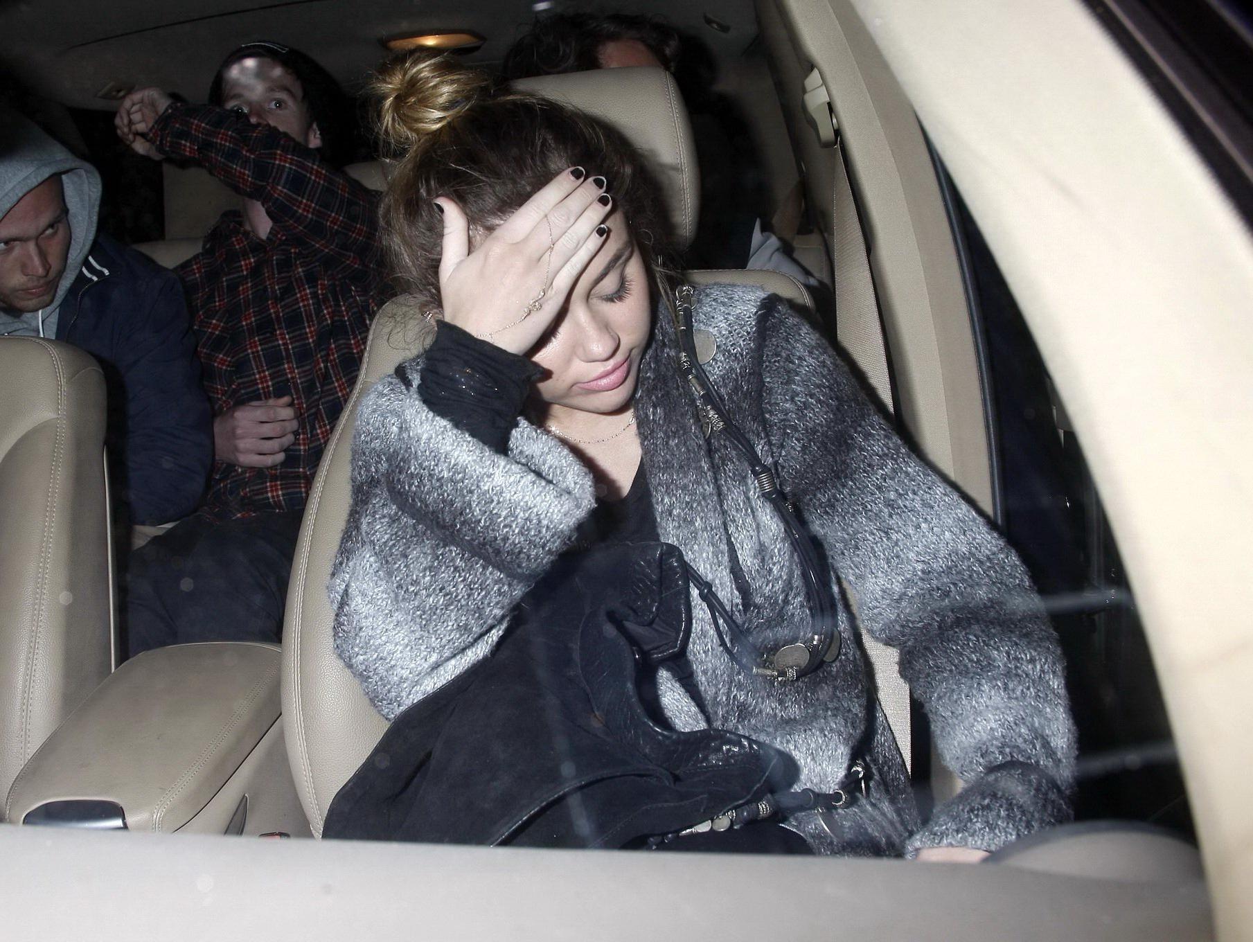 16P Miley Cyrus braless wearing black see through top outside a restaurant