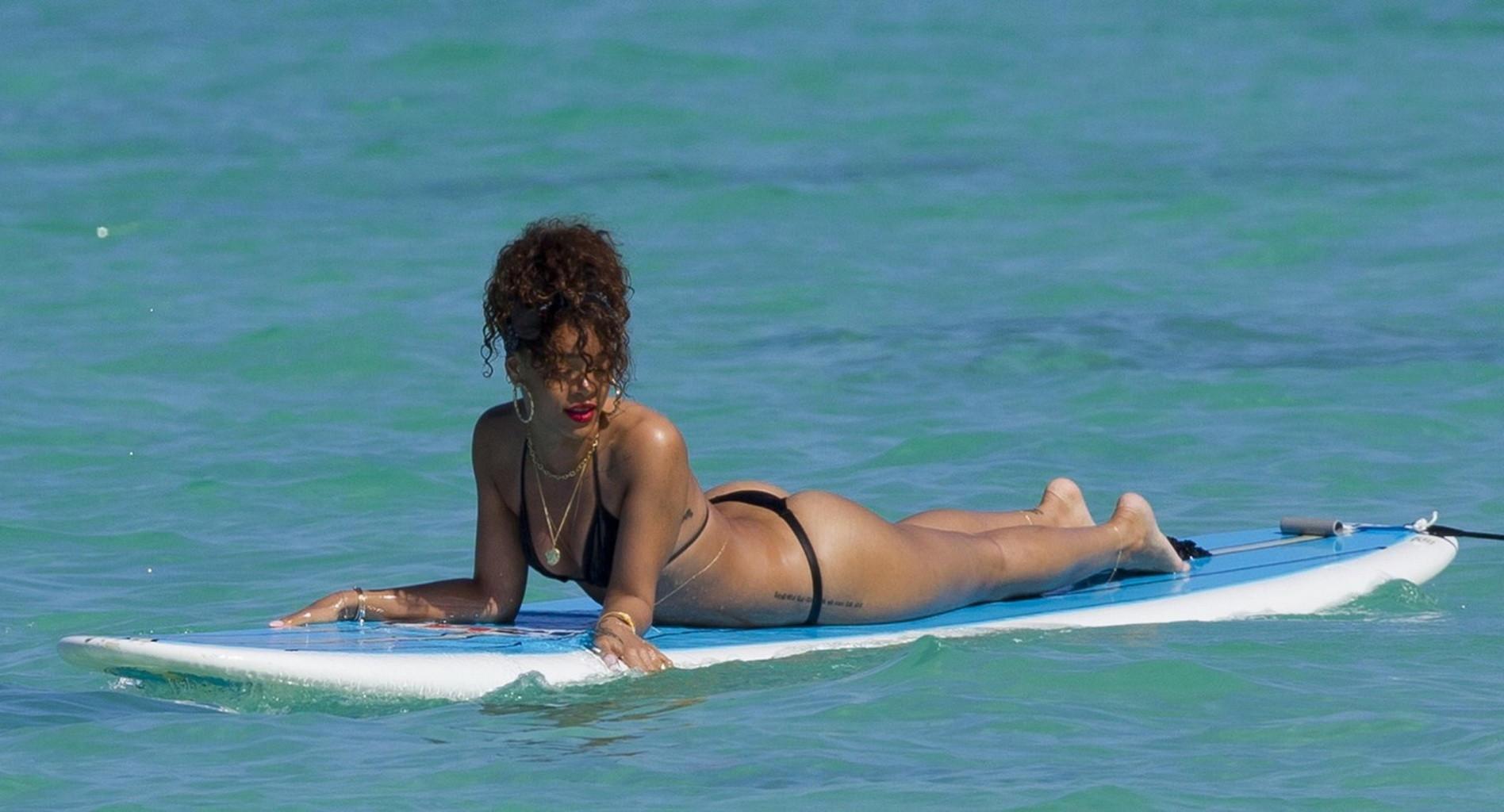 16P Rihanna shows off her ass wearing black thong bikini on a beach in Hawaii