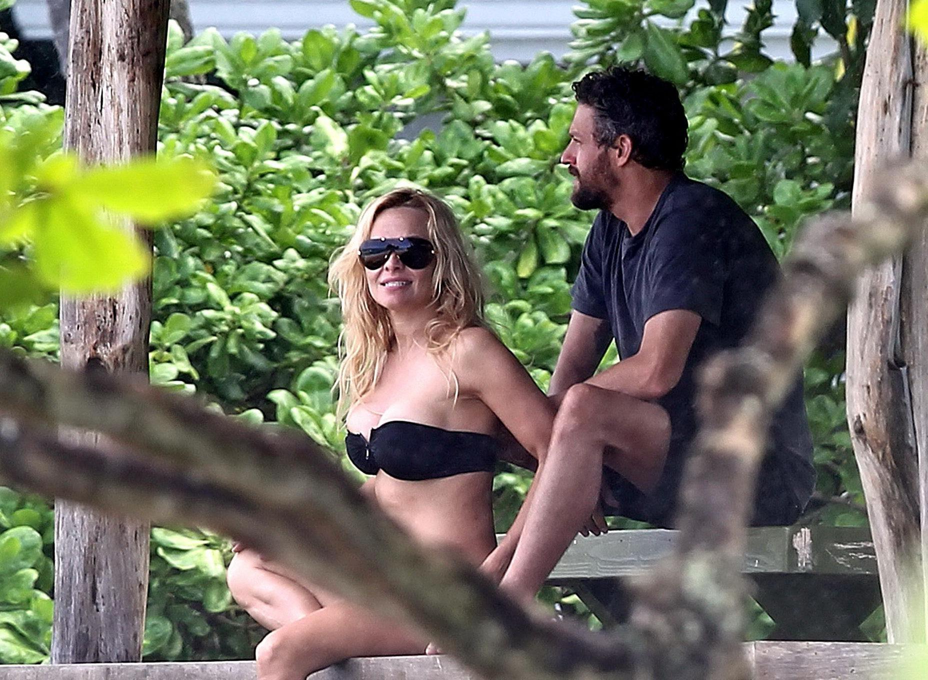 16P Pamela Anderson busty wearing strapless black bikini on a Hawaiian beach