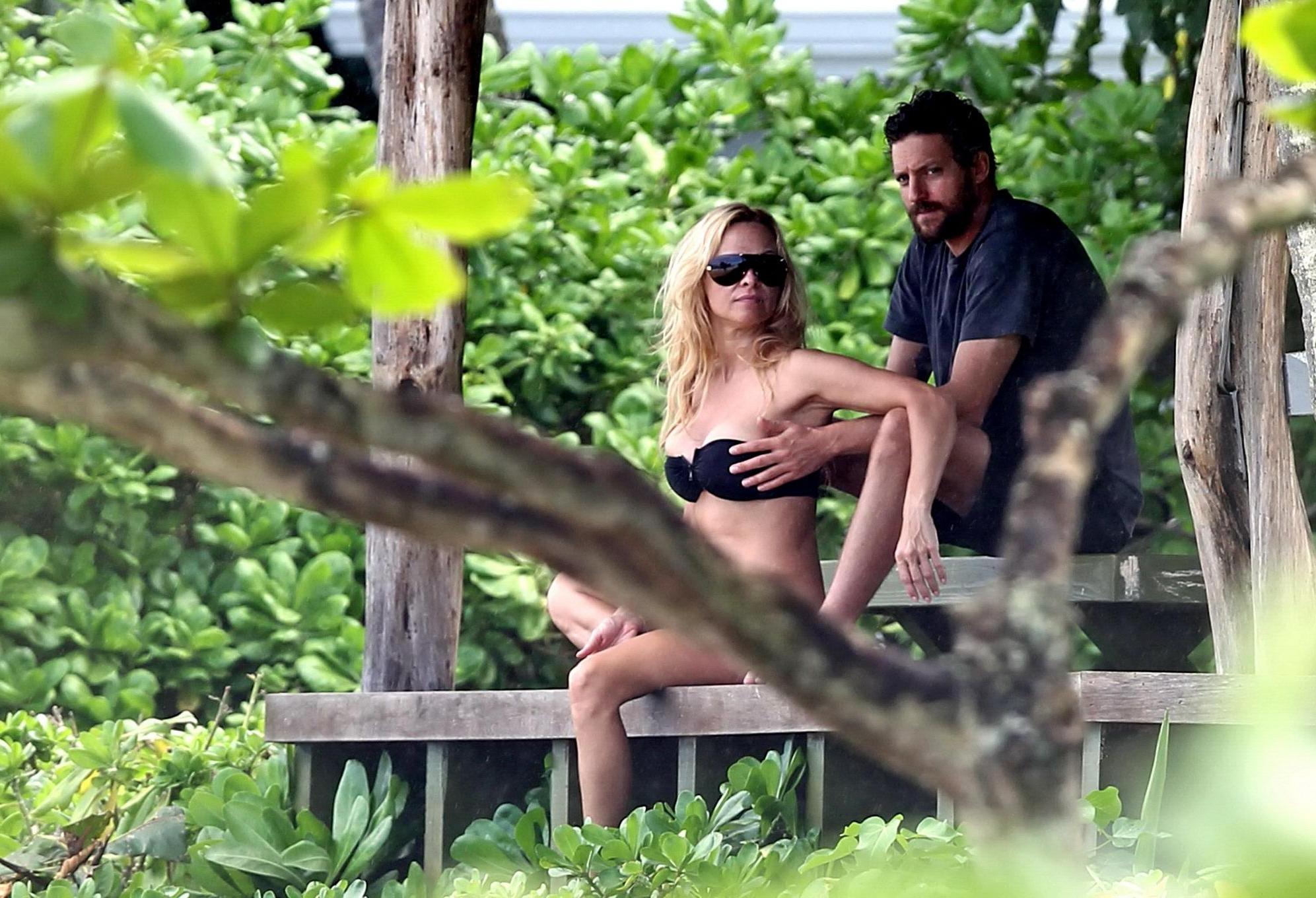 16P Pamela Anderson busty wearing strapless black bikini on a Hawaiian beach