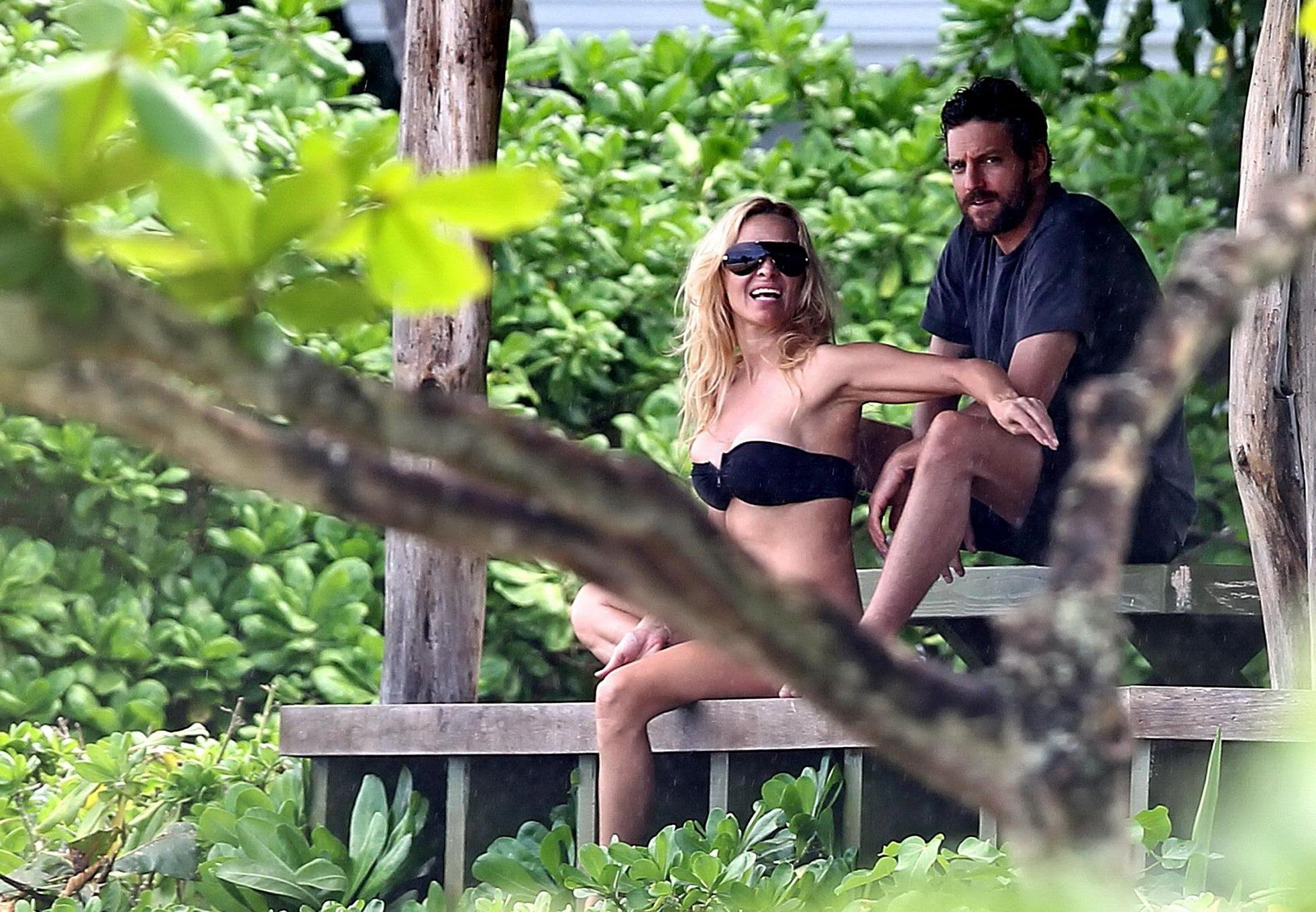 16P Pamela Anderson busty wearing strapless black bikini on a Hawaiian beach