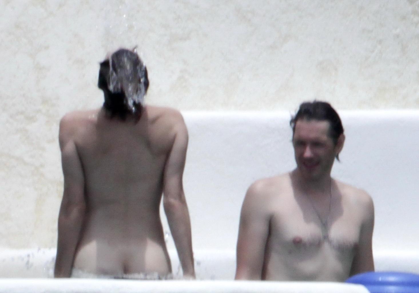 16P Milla Jovovich topless but hiding her boobs in Cabo San Lucas