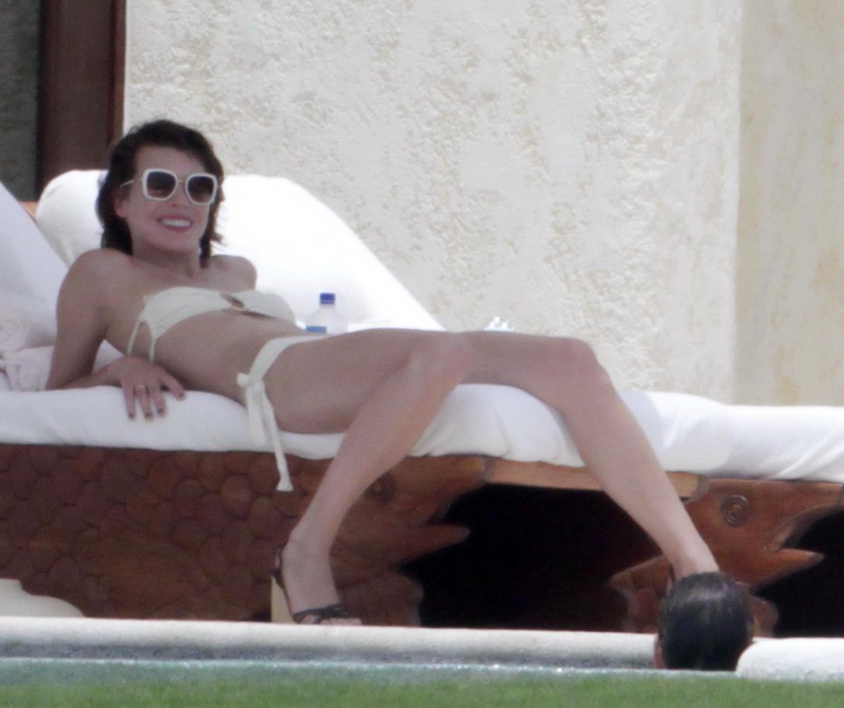 16P Milla Jovovich topless but hiding her boobs in Cabo San Lucas