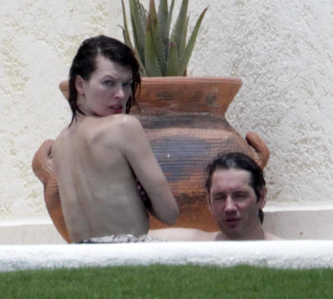16P Milla Jovovich topless but hiding her boobs in Cabo San Lucas