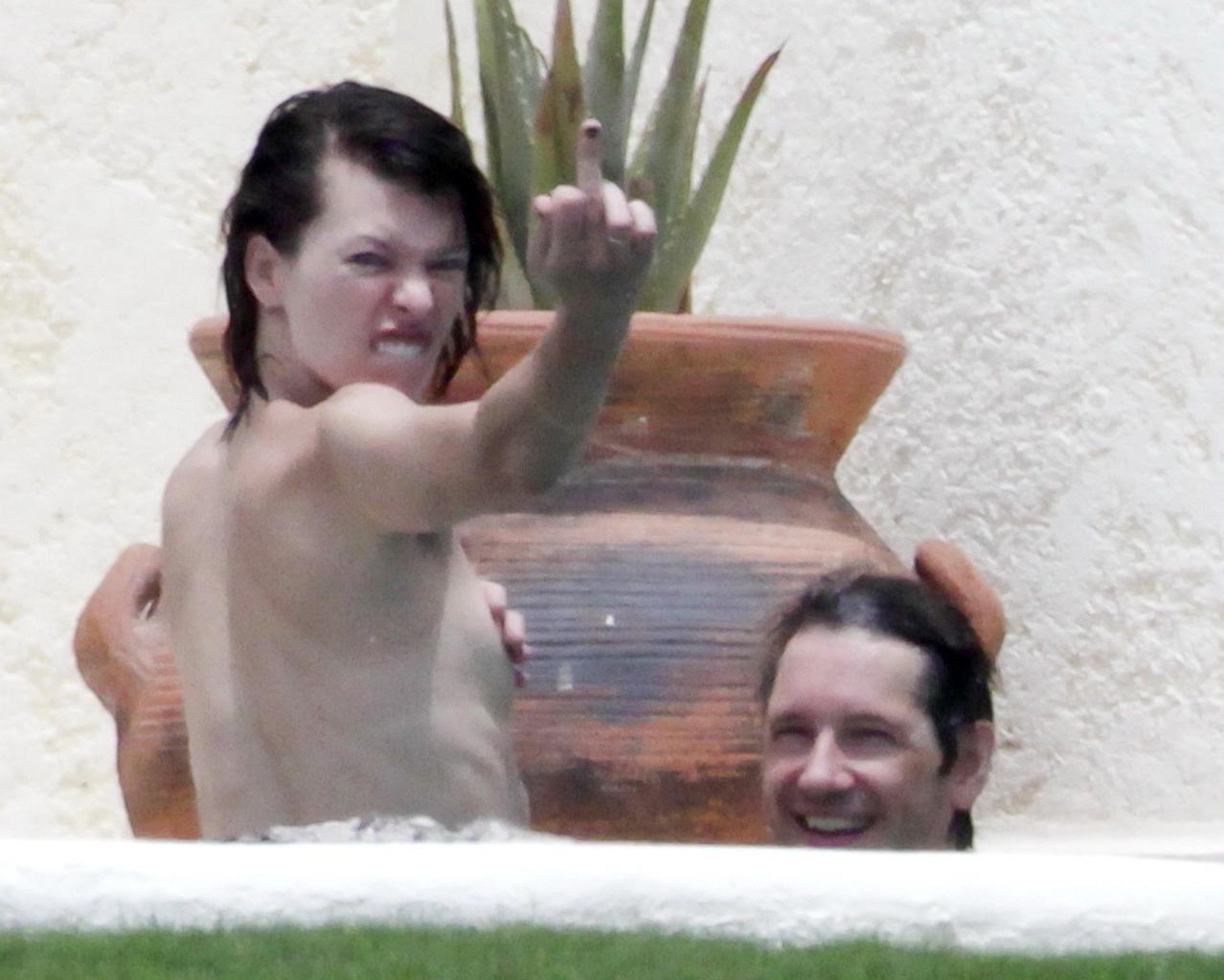 16P Milla Jovovich topless but hiding her boobs in Cabo San Lucas