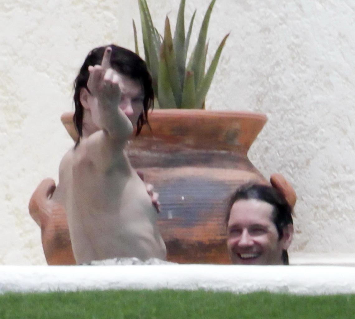 16P Milla Jovovich topless but hiding her boobs in Cabo San Lucas