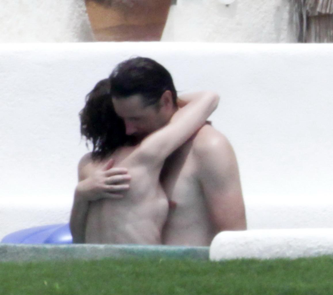 16P Milla Jovovich topless but hiding her boobs in Cabo San Lucas
