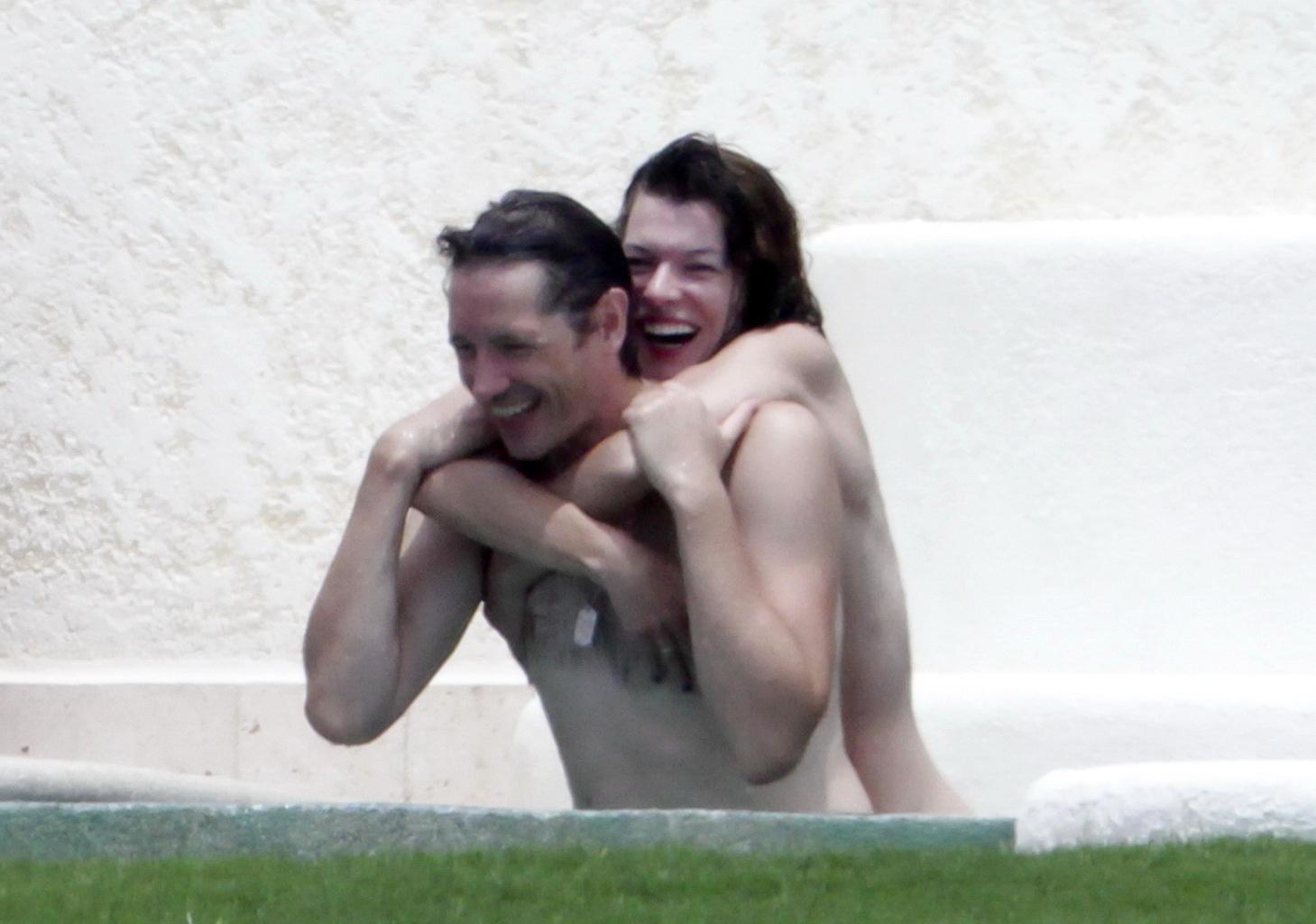 16P Milla Jovovich topless but hiding her boobs in Cabo San Lucas