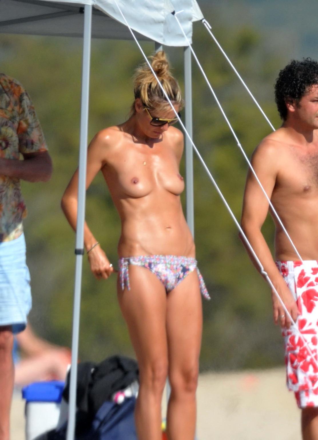 16P Heidi Klum tanning topless on a sandy beach in Corsica