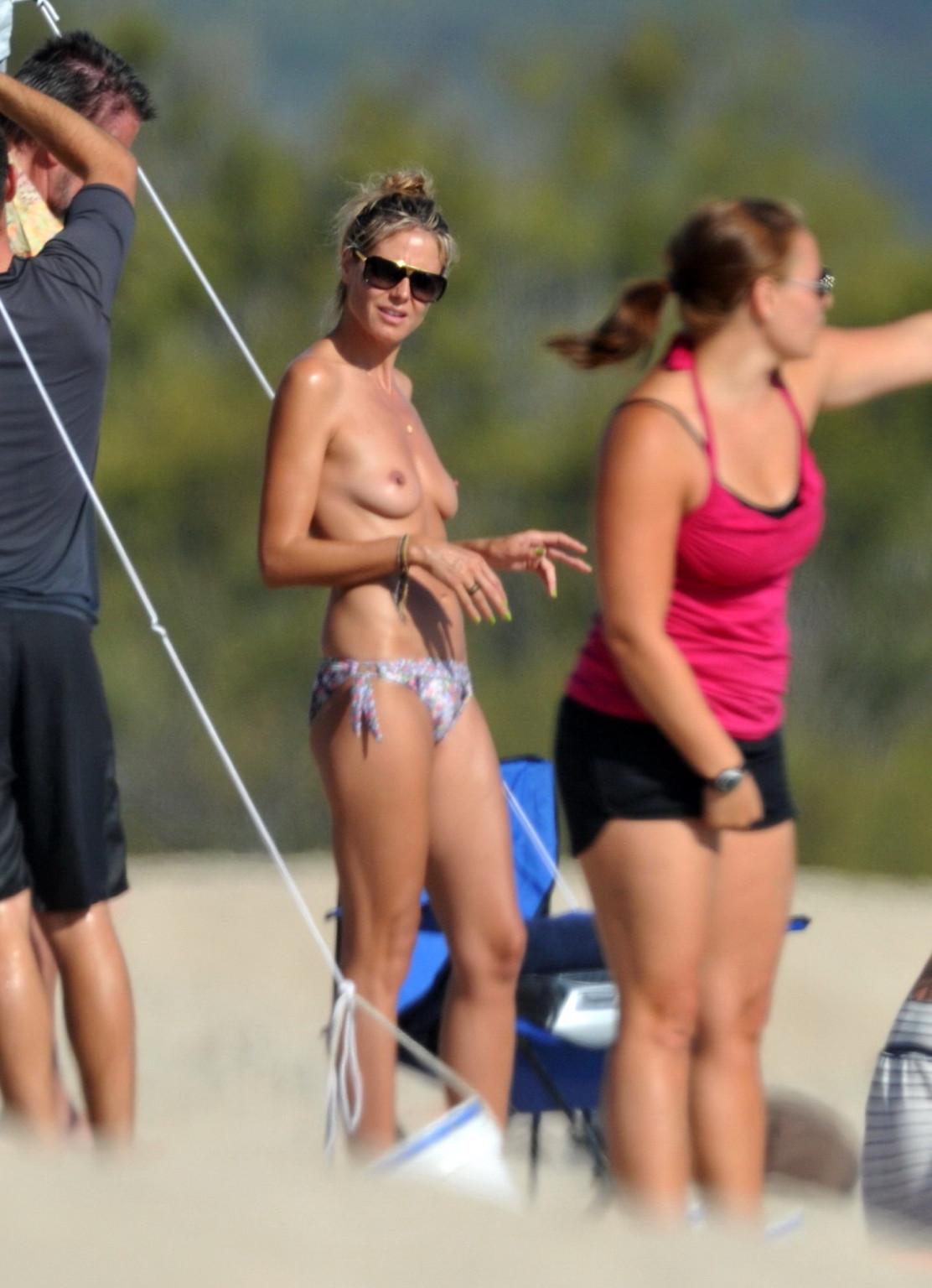 16P Heidi Klum tanning topless on a sandy beach in Corsica