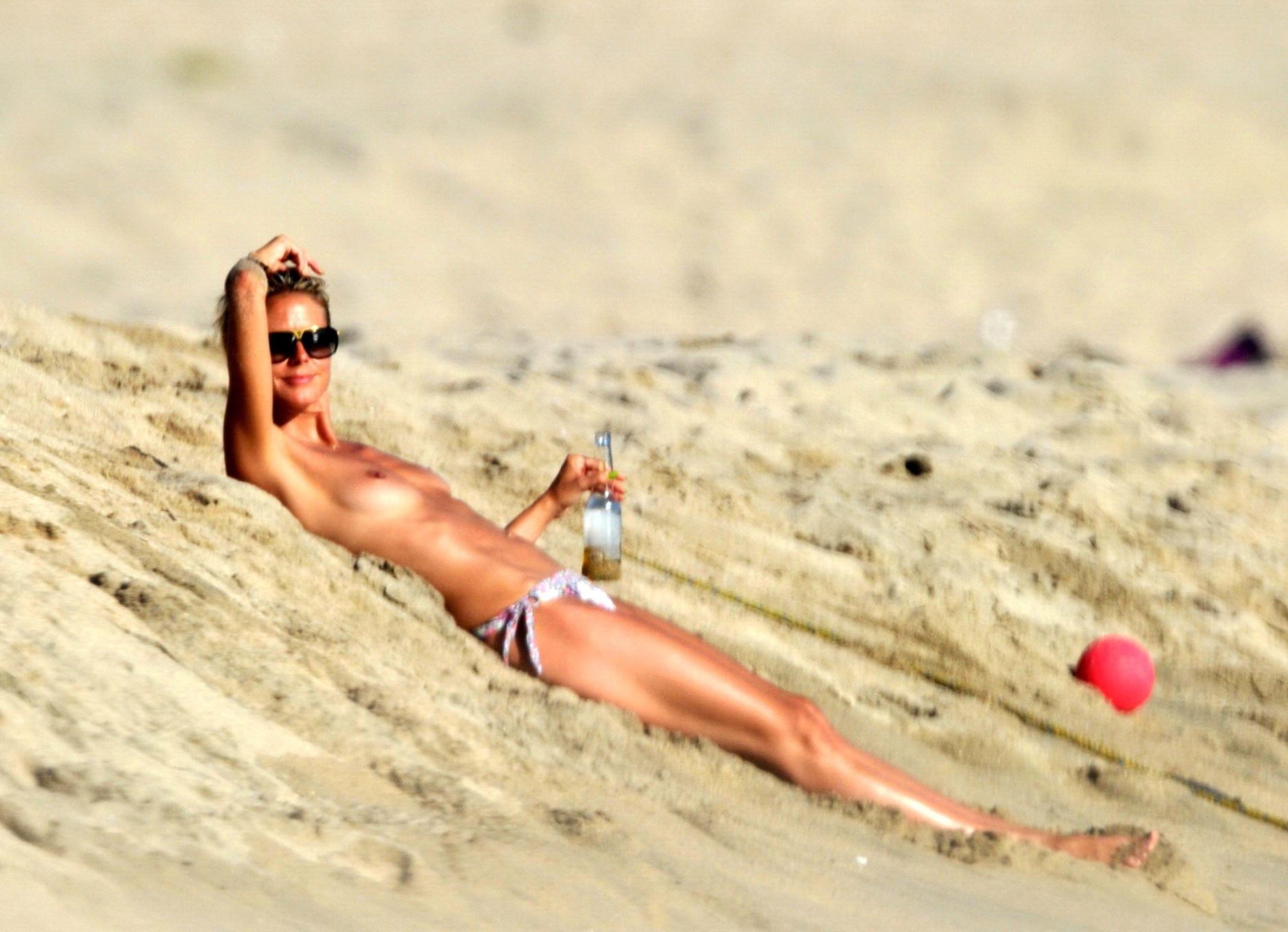 16P Heidi Klum tanning topless on a sandy beach in Corsica