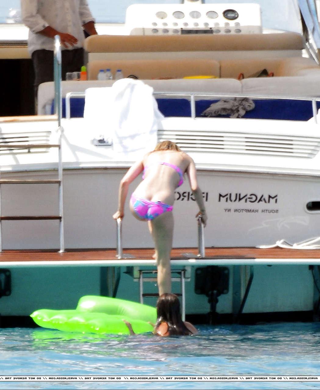 16P Avril Lavigne showing part of her ass and nipple slip in bikini on beach