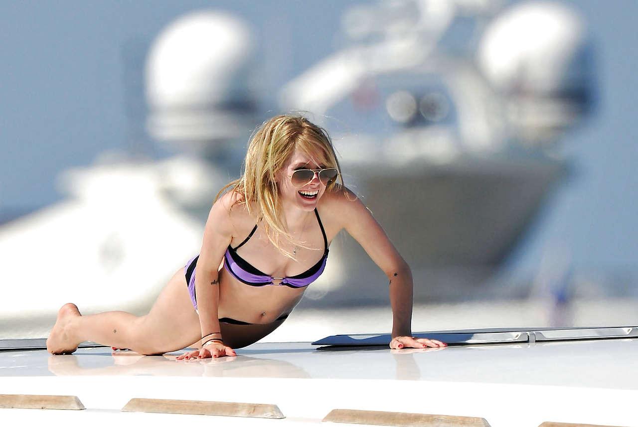 16P Avril Lavigne showing part of her ass and nipple slip in bikini on beach