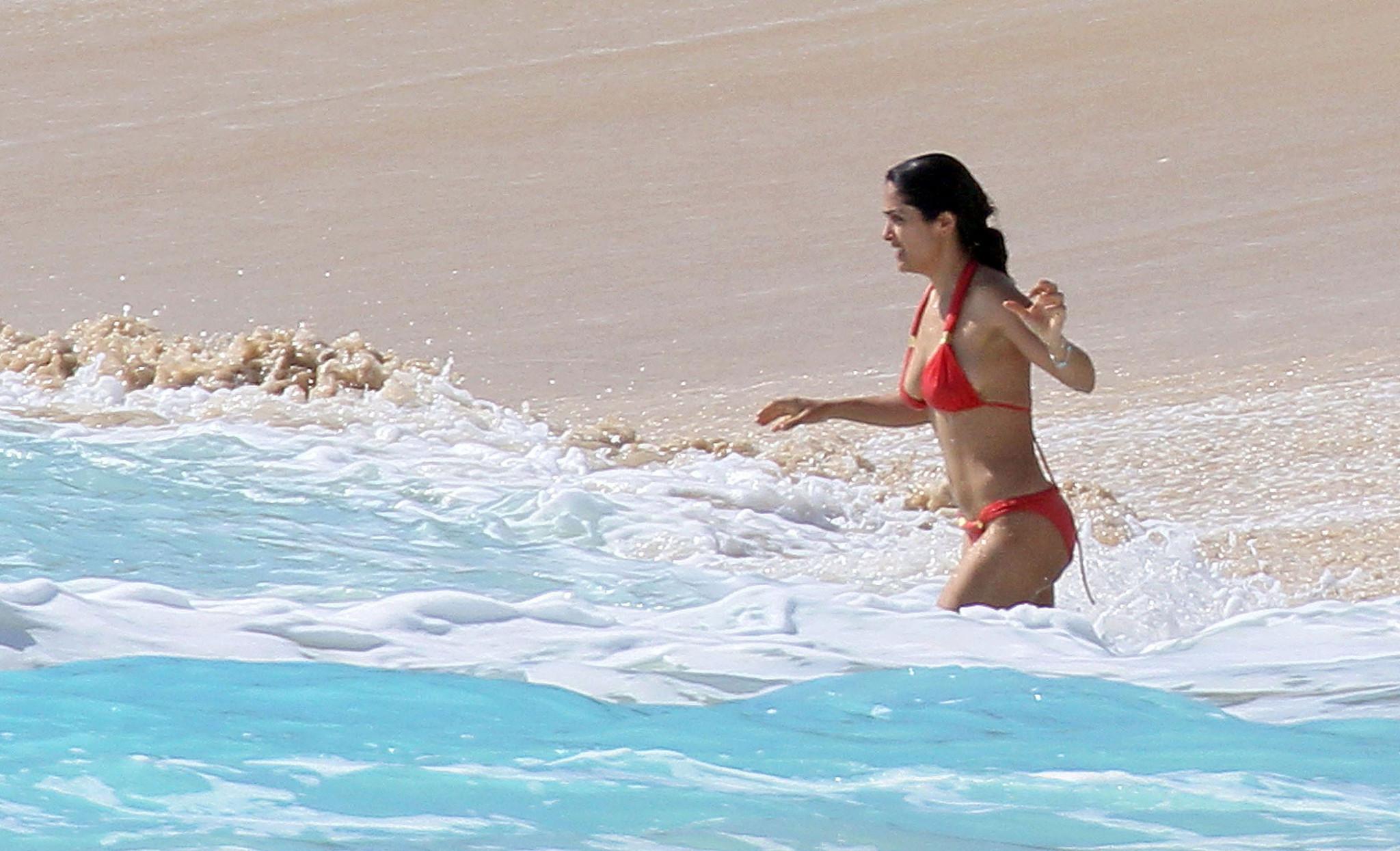 16P Salma Hayek exposing sexy body and huge boobs in red bikini on beach