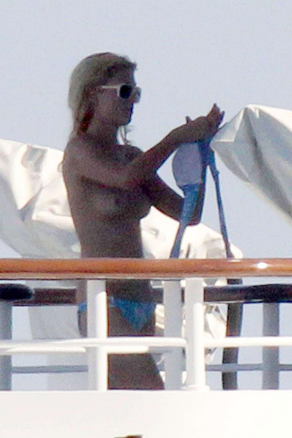 10P Paris Hilton exposing her nice tits while sunbathing topless on yacht paparazzi 