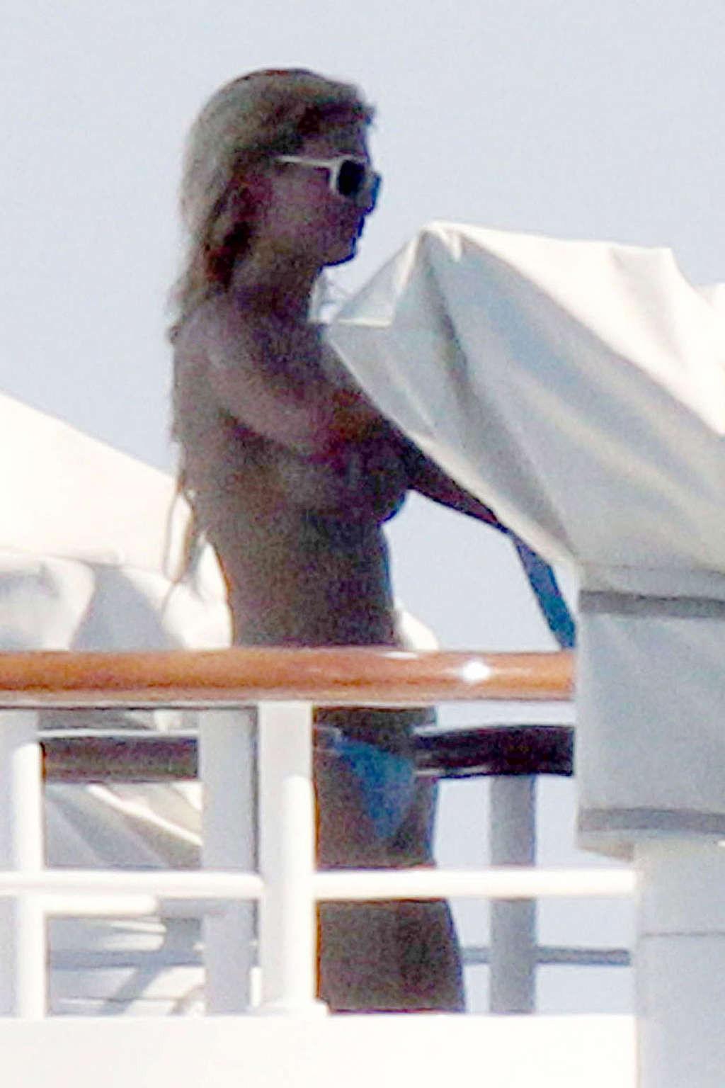 10P Paris Hilton exposing her nice tits while sunbathing topless on yacht paparazzi 
