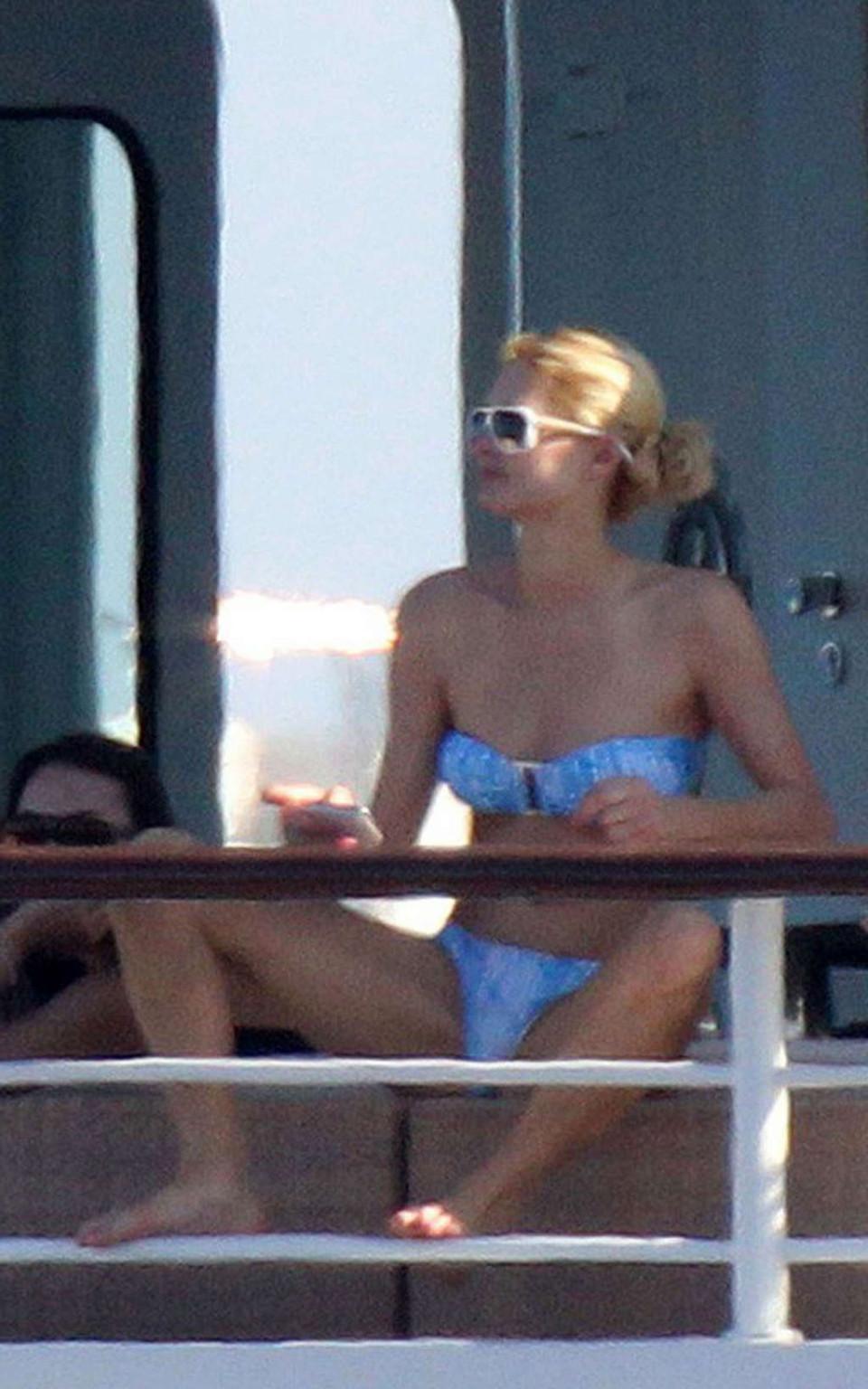 10P Paris Hilton exposing her nice tits while sunbathing topless on yacht paparazzi 
