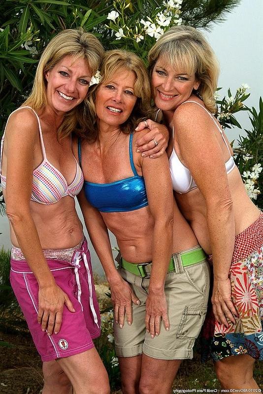 15P Three mature women posing on beach